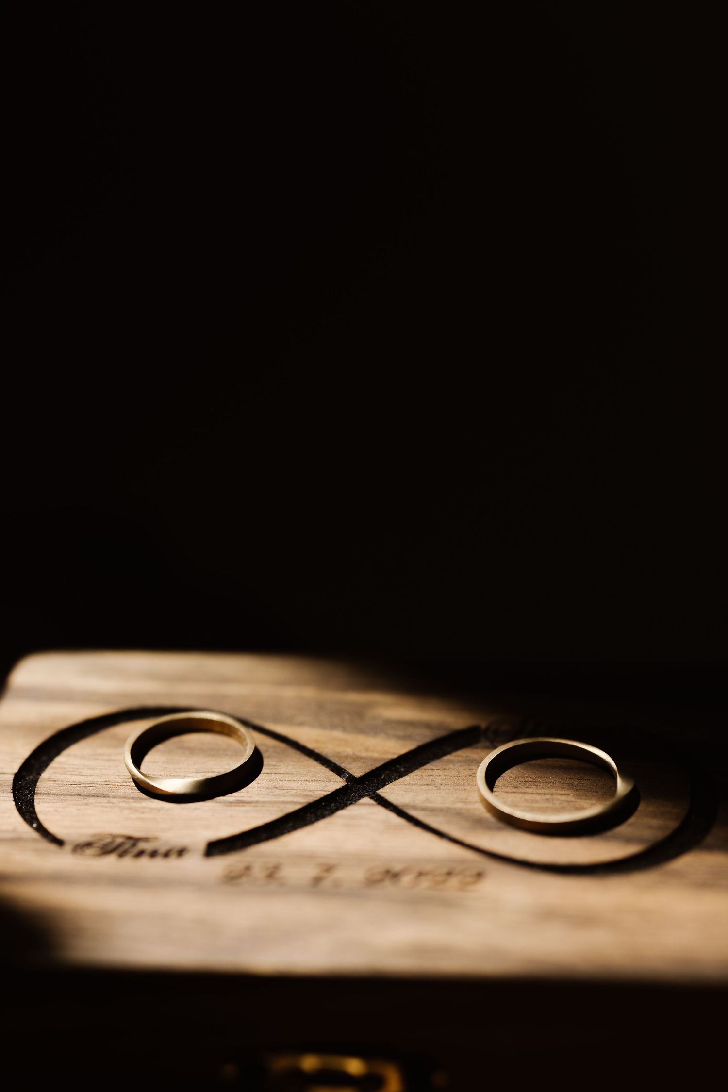 Close-up of infinity symbol carved in wood with dramatic lighting.