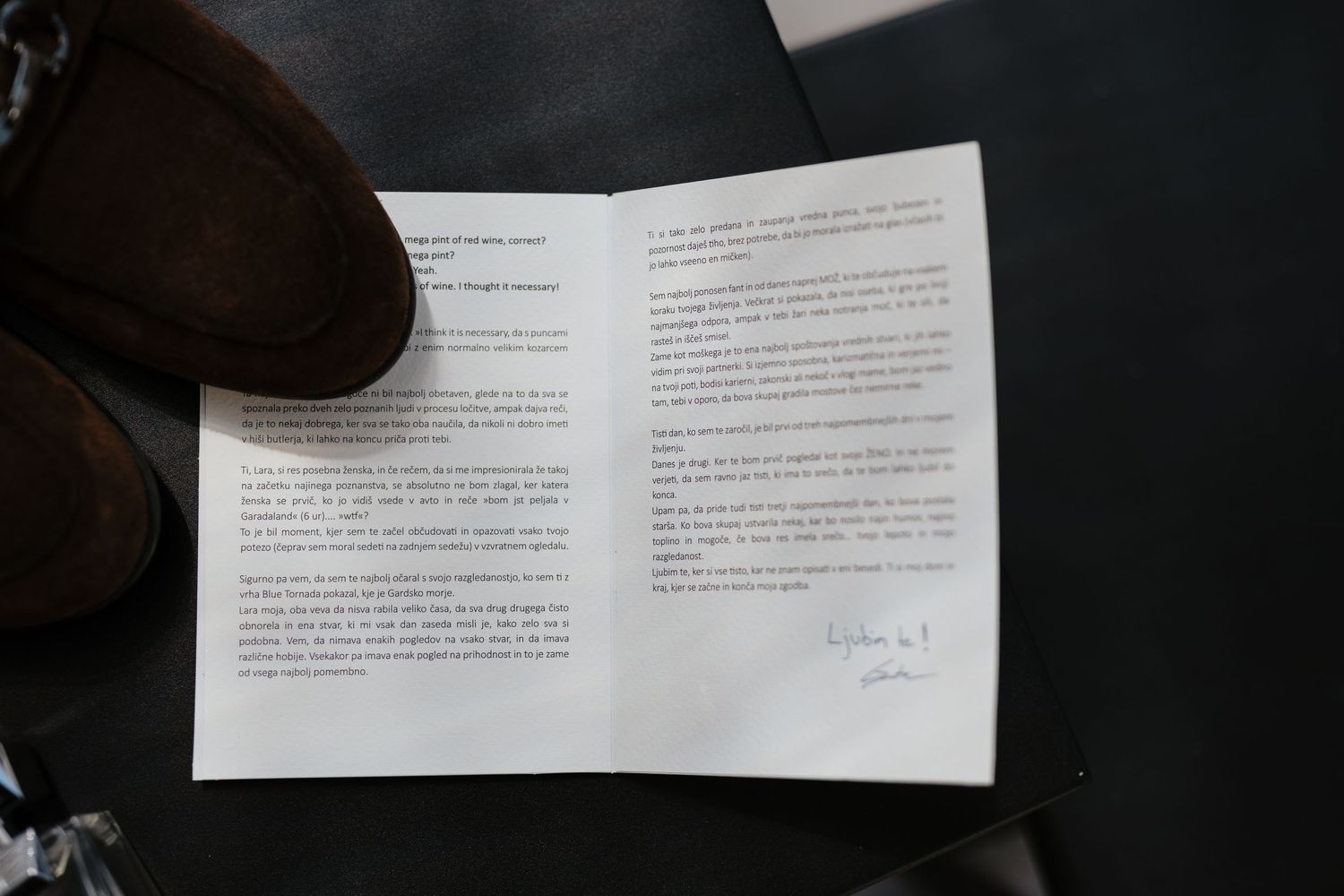 Open document pages laid out on dark surface showing printed text.