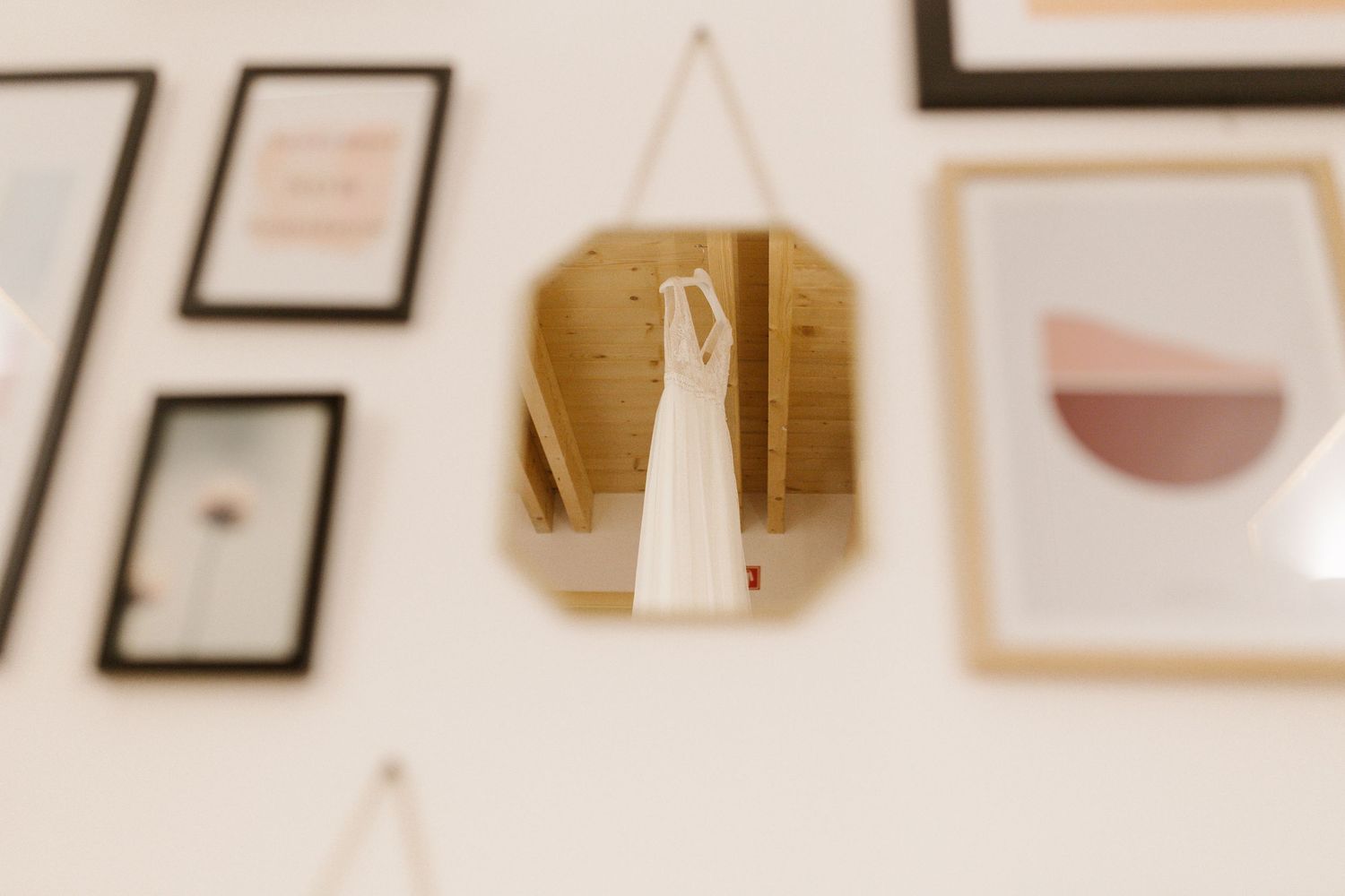 A collection of framed artwork and photos arranged in a gallery wall style with a minimalist aesthetic.