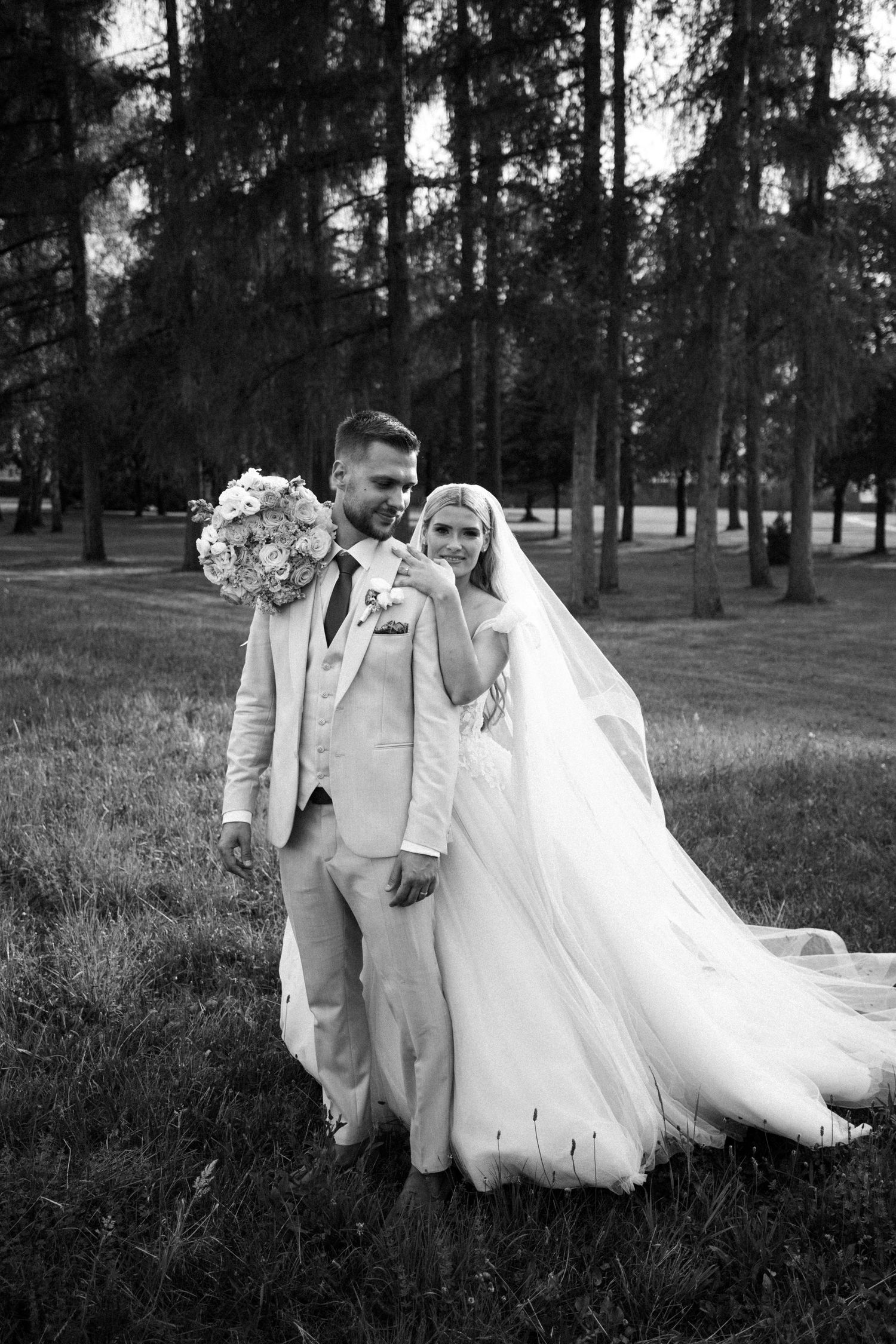 A black and white wedding portrait sequence showing a couple walking together in a wooded outdoor setting.