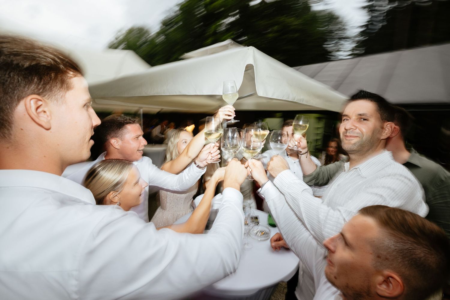 Wedding party celebrates with champagne toast in candid moment.