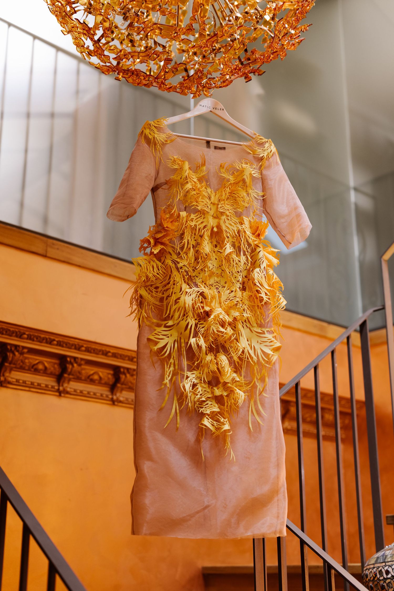 Glowing orange floral decorative light fixture illuminates a stairwell with warm ambient lighting.