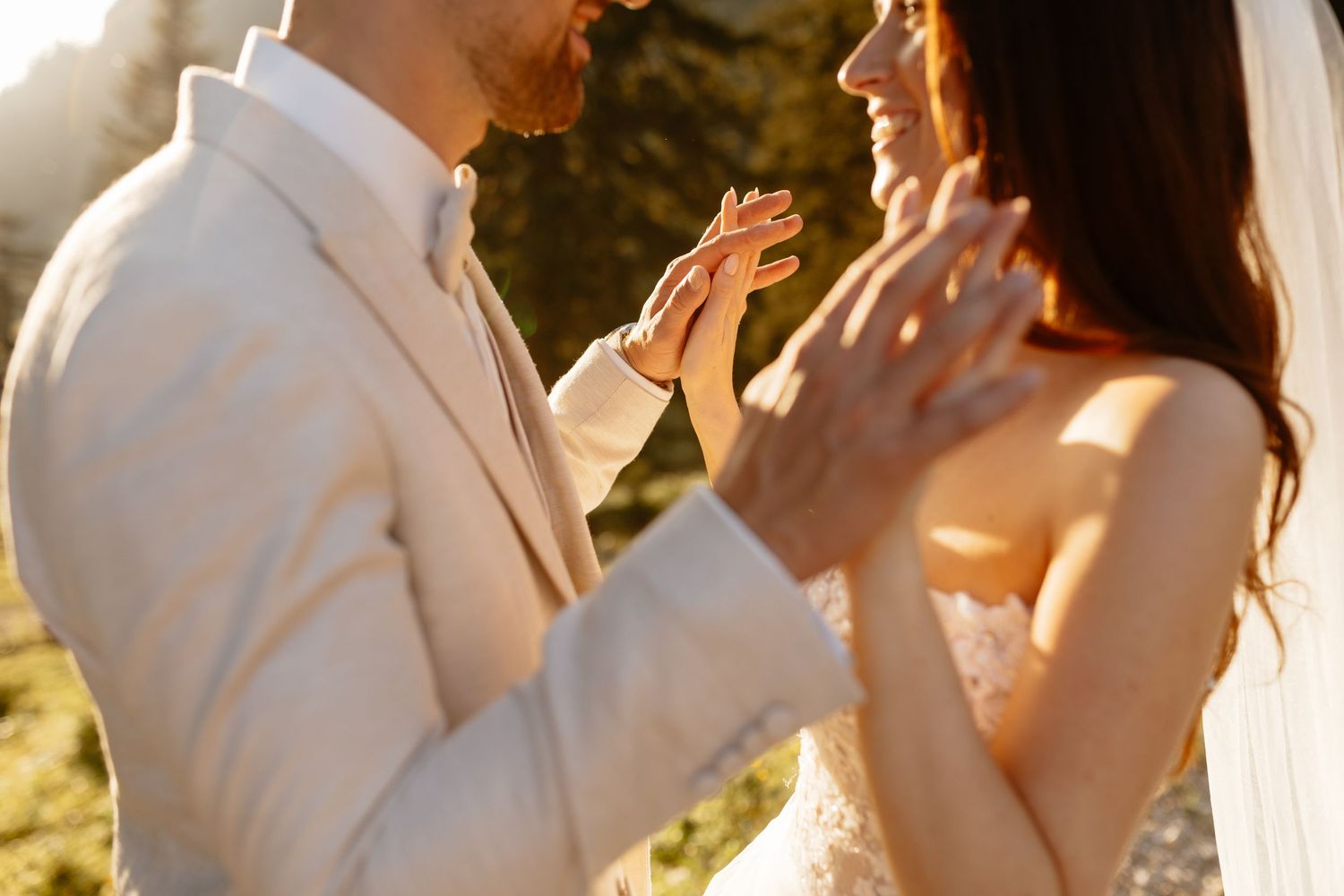Newlyweds share joyful laughter during golden hour wedding photoshoot.