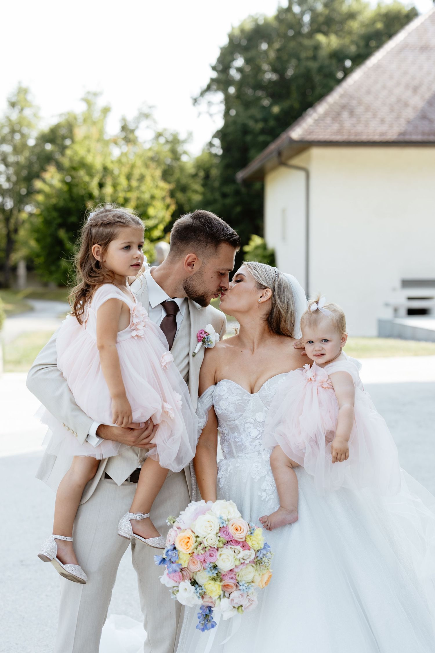 Romantic outdoor wedding portraits with pastel floral bouquet and white bridal gown.