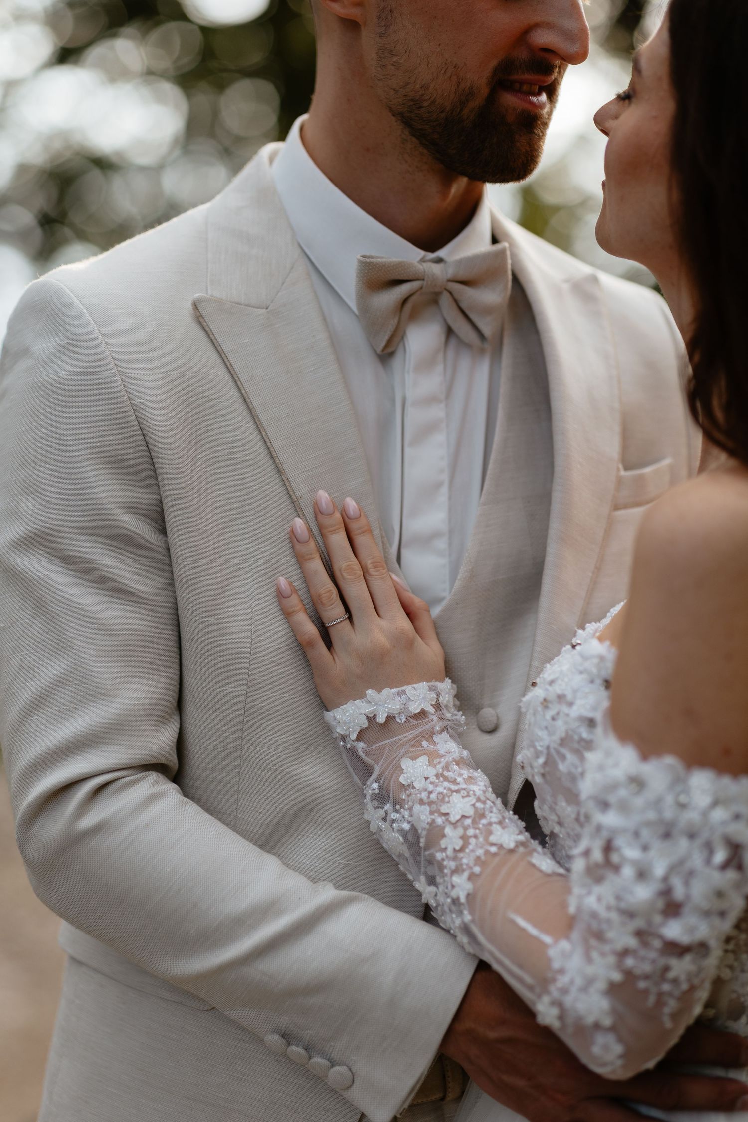 Close-up of couple in white wedding attire sharing an intimate moment.