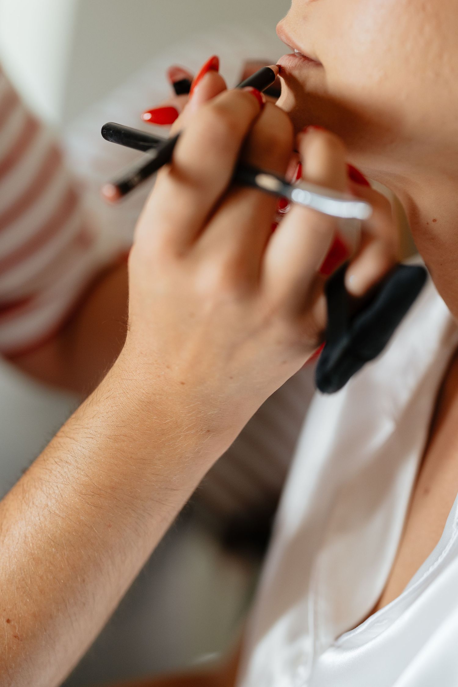 Close-up of hands holding a pen against a light background.