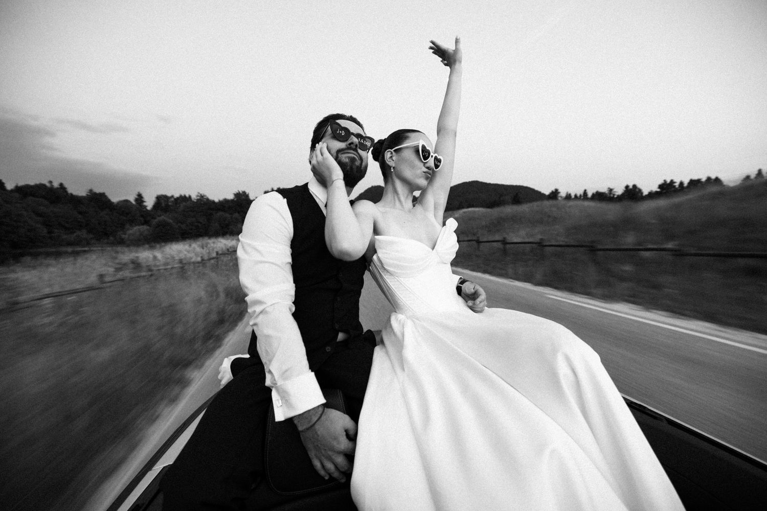Black and white photo sequence of a couple in wedding attire driving away in a vintage convertible car.