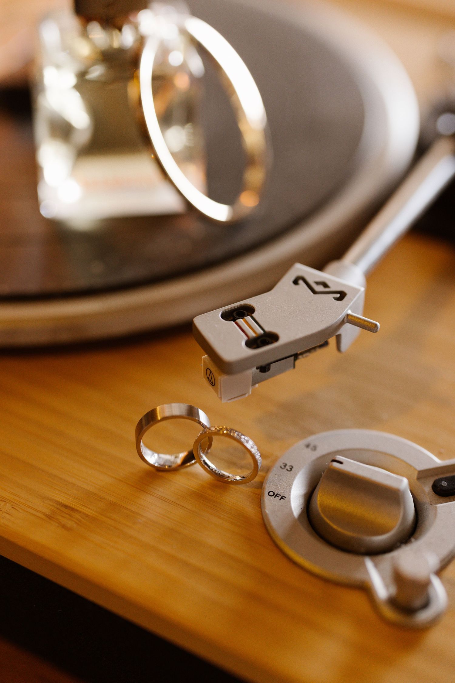Close-up sequence of wedding rings being arranged on a wooden surface in natural light.