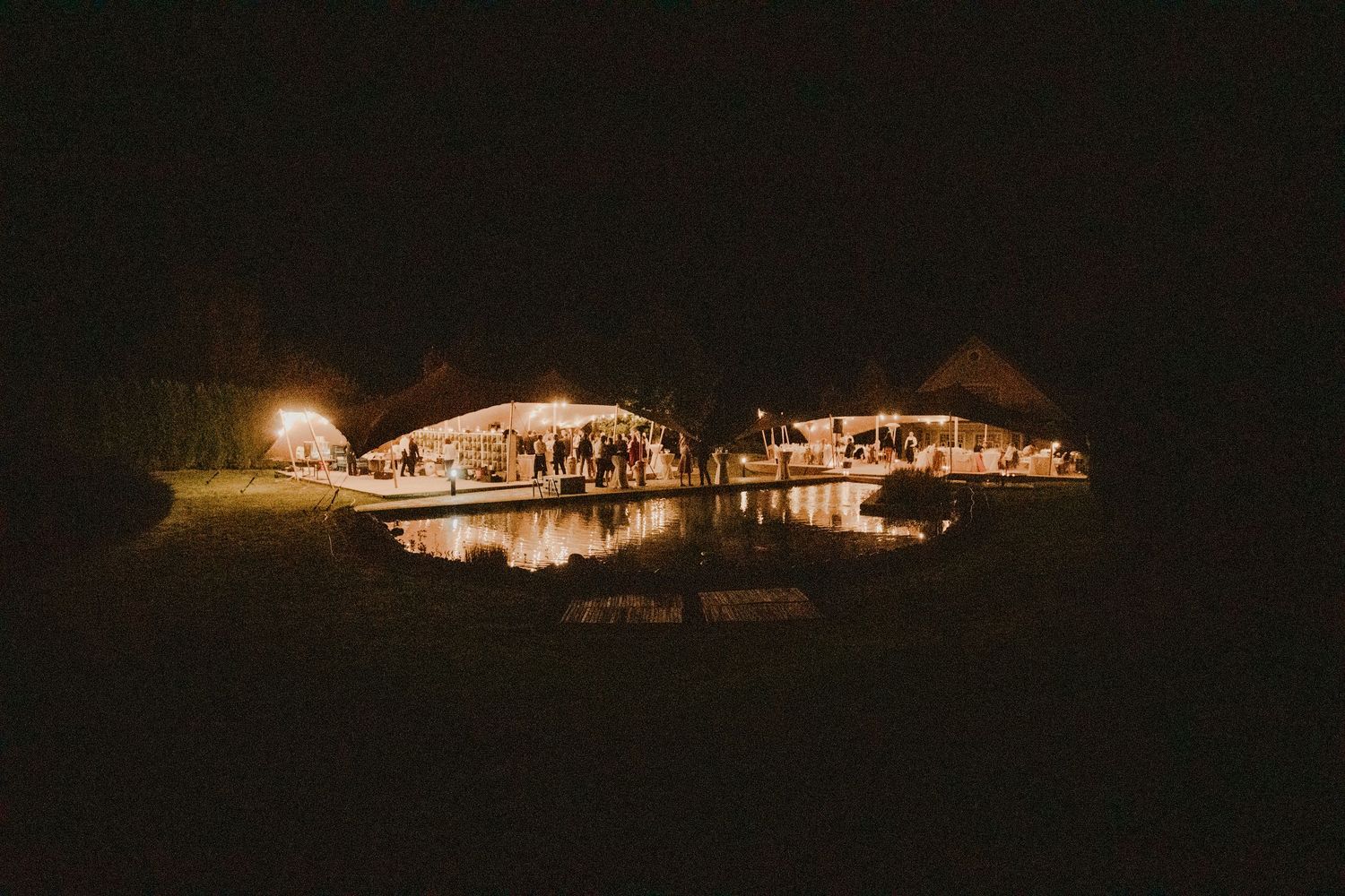 Panoramic nighttime view of an illuminated wedding venue glowing in the darkness.