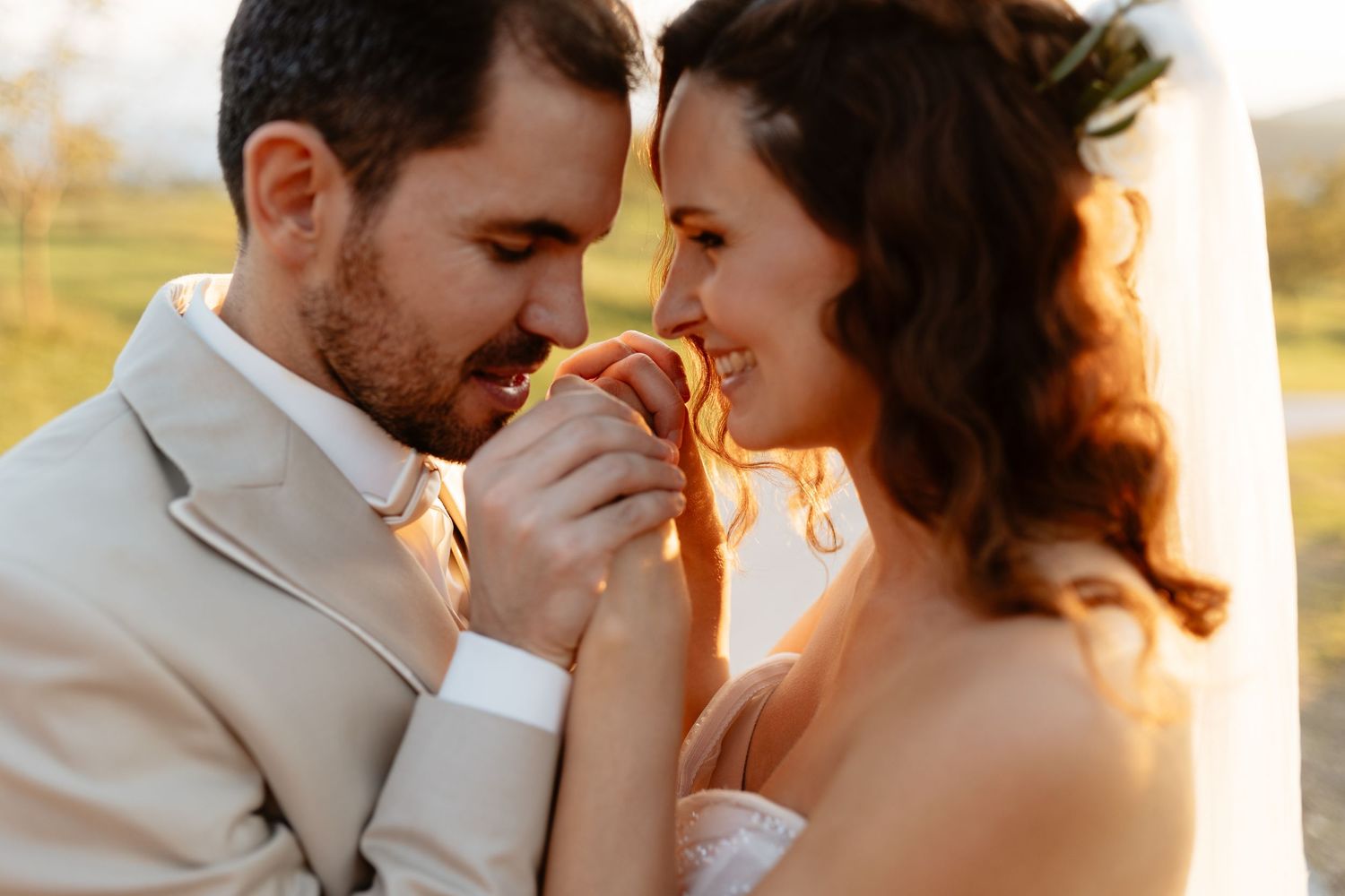 Romantic sunset portrait of newlyweds sharing intimate moments in golden hour light.