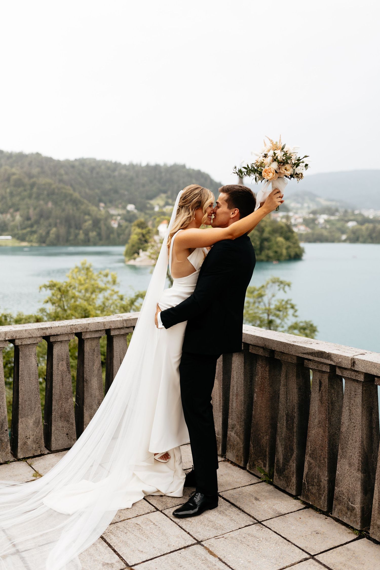 Romantic wedding dance sequence on a lakeside deck with mountain views.