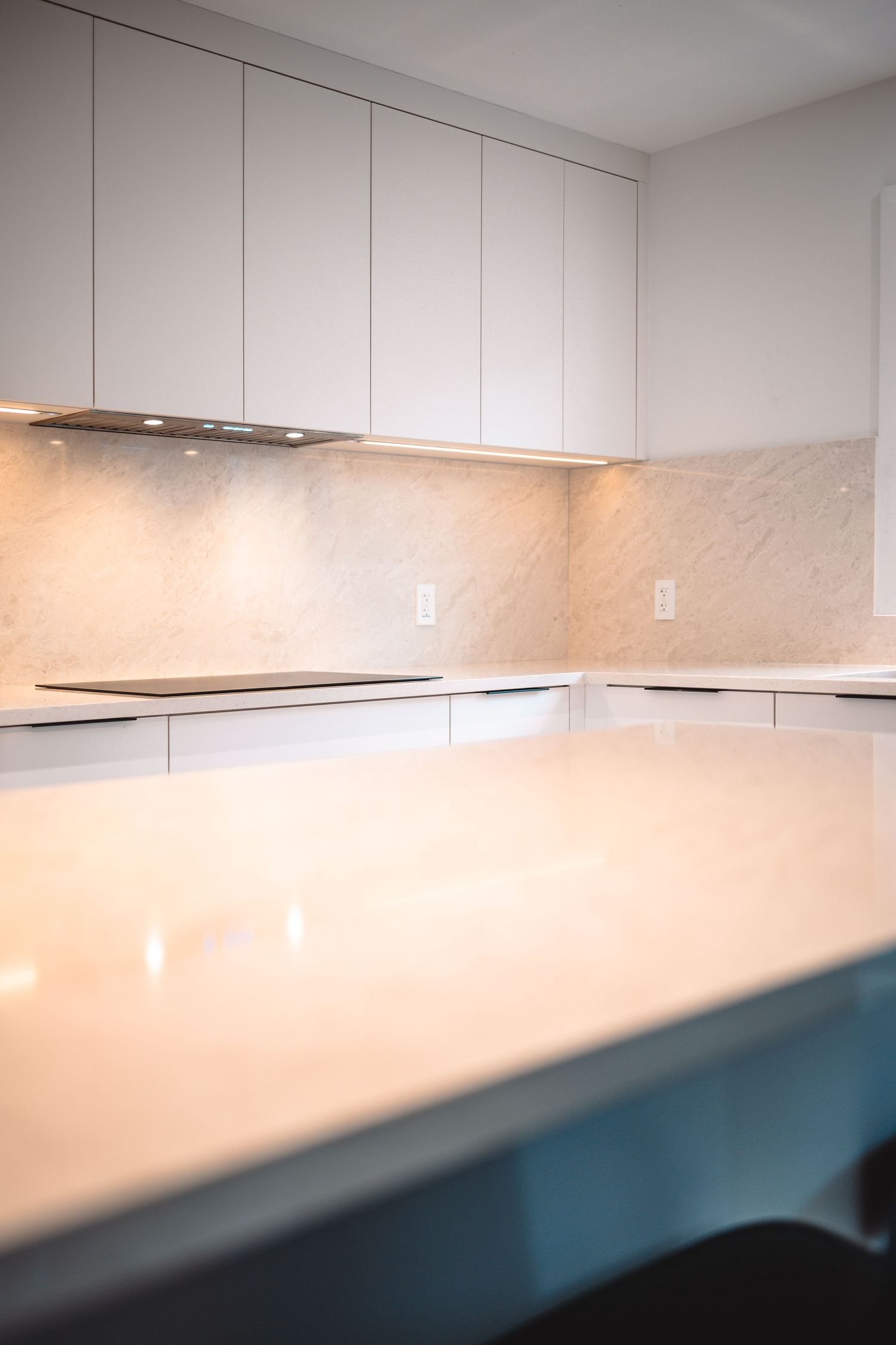 Modern white kitchen backsplash with under-cabinet lighting and sleek minimalist design.