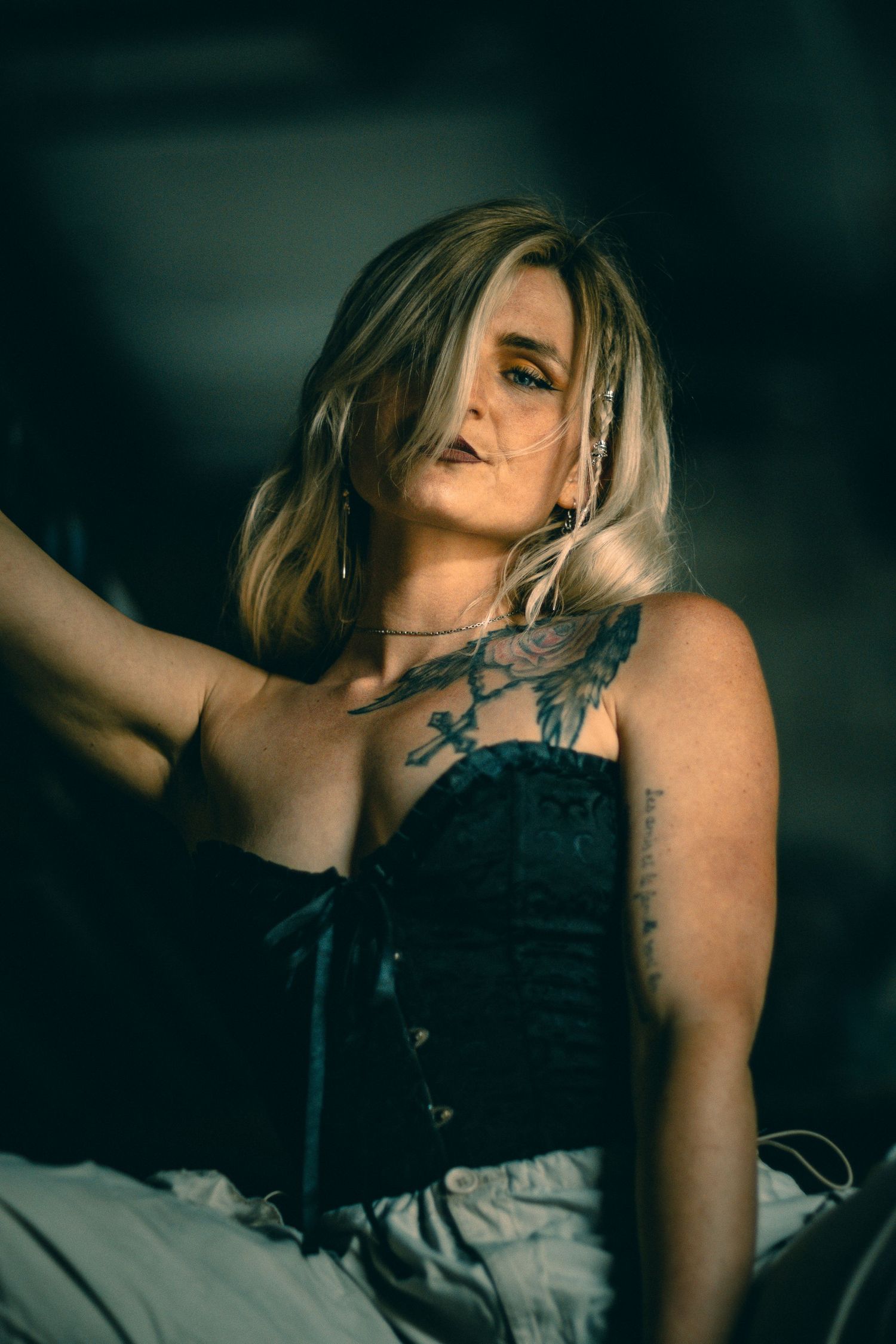 Dramatic boudoir portrait series in dark moody lighting with artistic angles.
