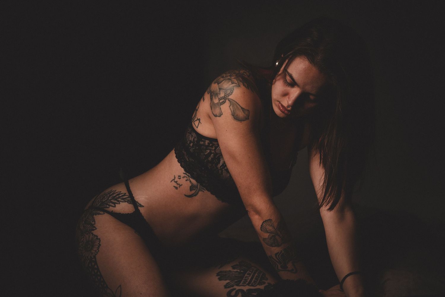 Dark moody boudoir photoshoot with artistic silhouettes and shadows.