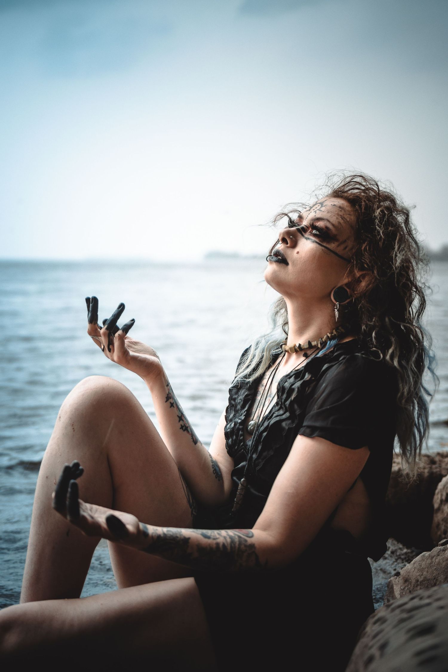 Artistic sequence of moody portraits captured at the beach with dramatic lighting and ocean backdrop.