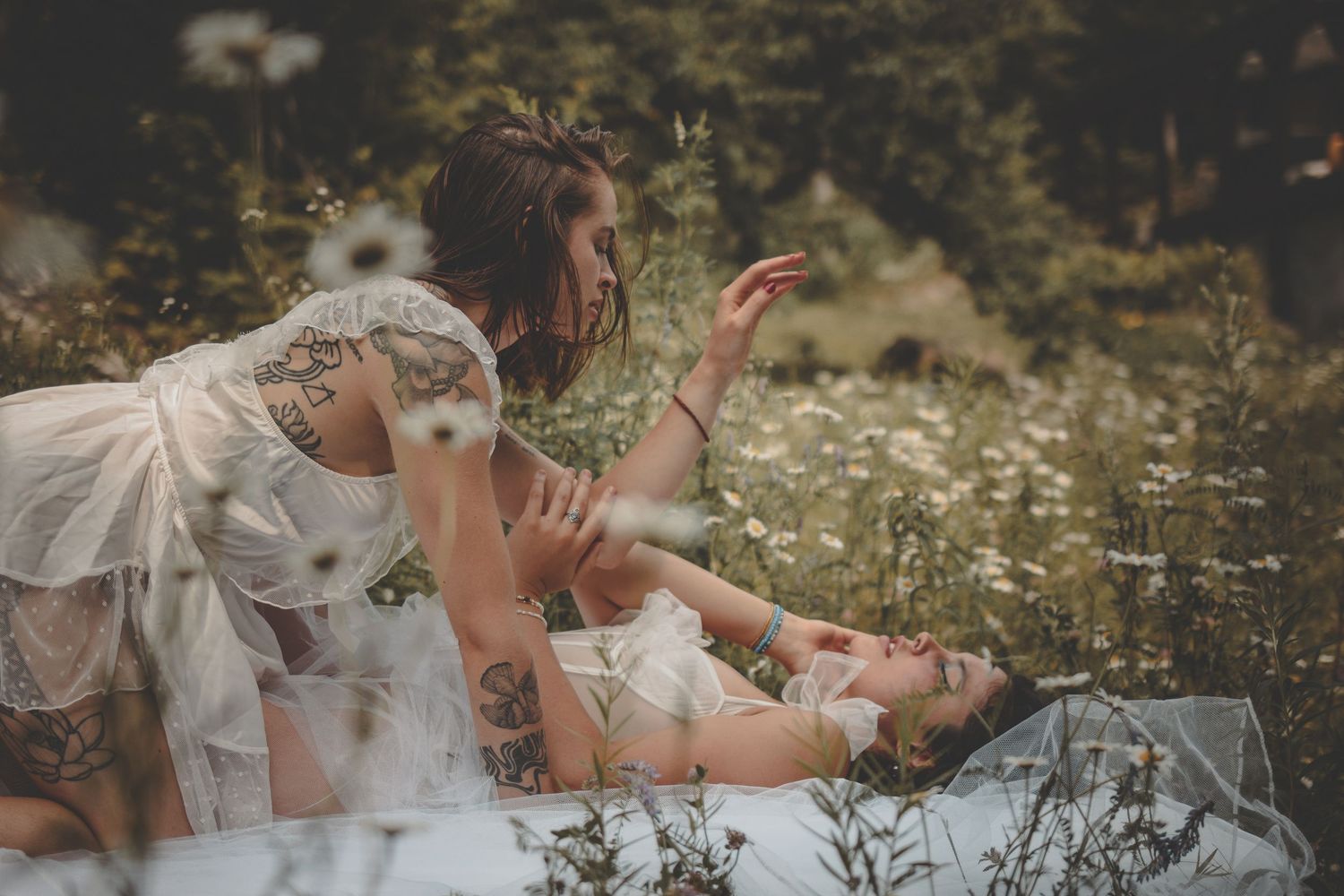 Romantic outdoor photoshoot with wildflowers and soft natural lighting creating a dreamy atmosphere.