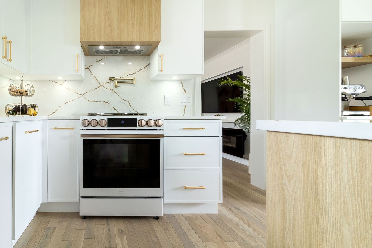 Contemporary kitchen with white cabinets, wood accents, and stainless steel appliances.