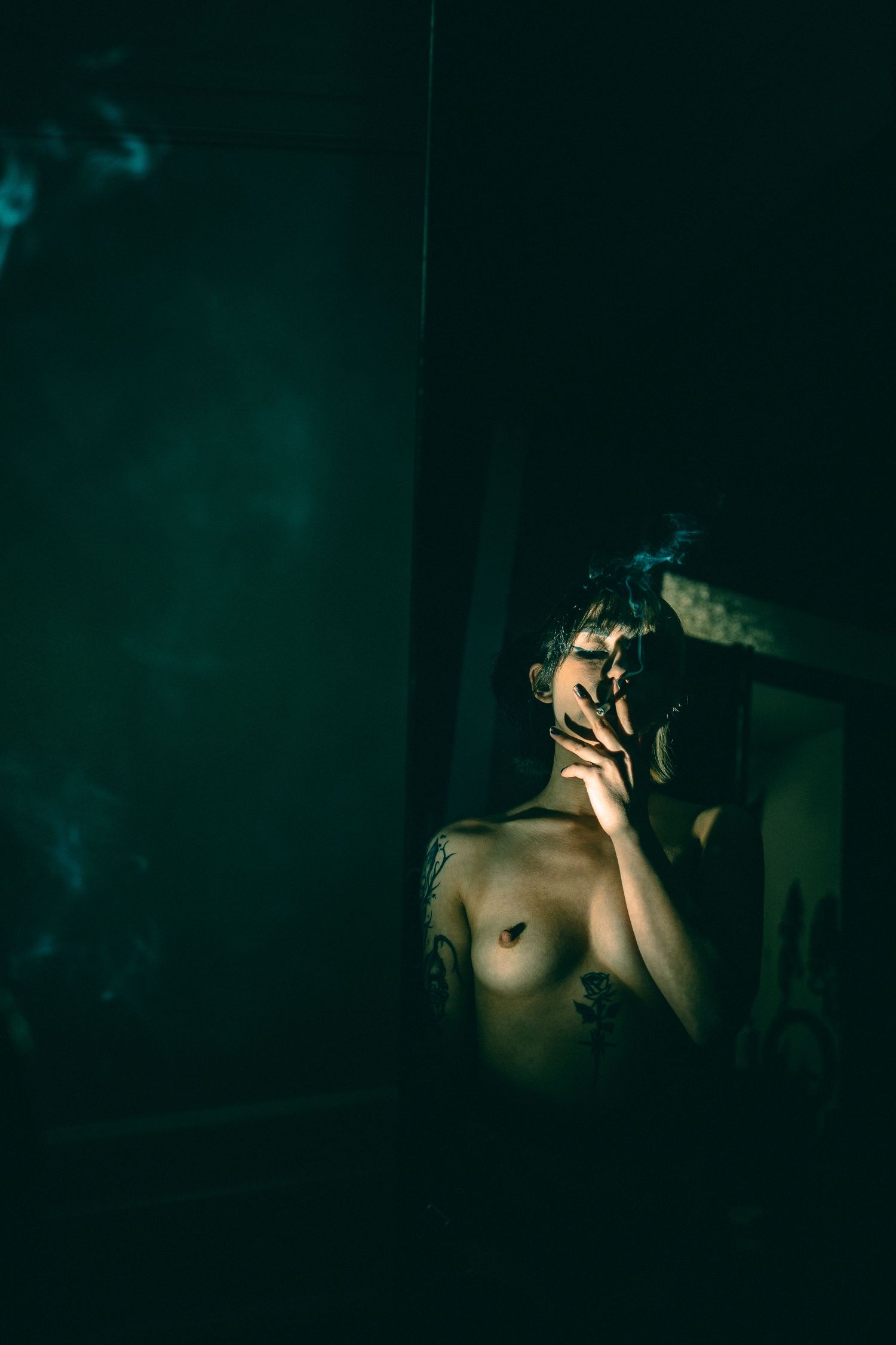 A dark and moody series of artistic portraits with teal lighting and dramatic shadows.