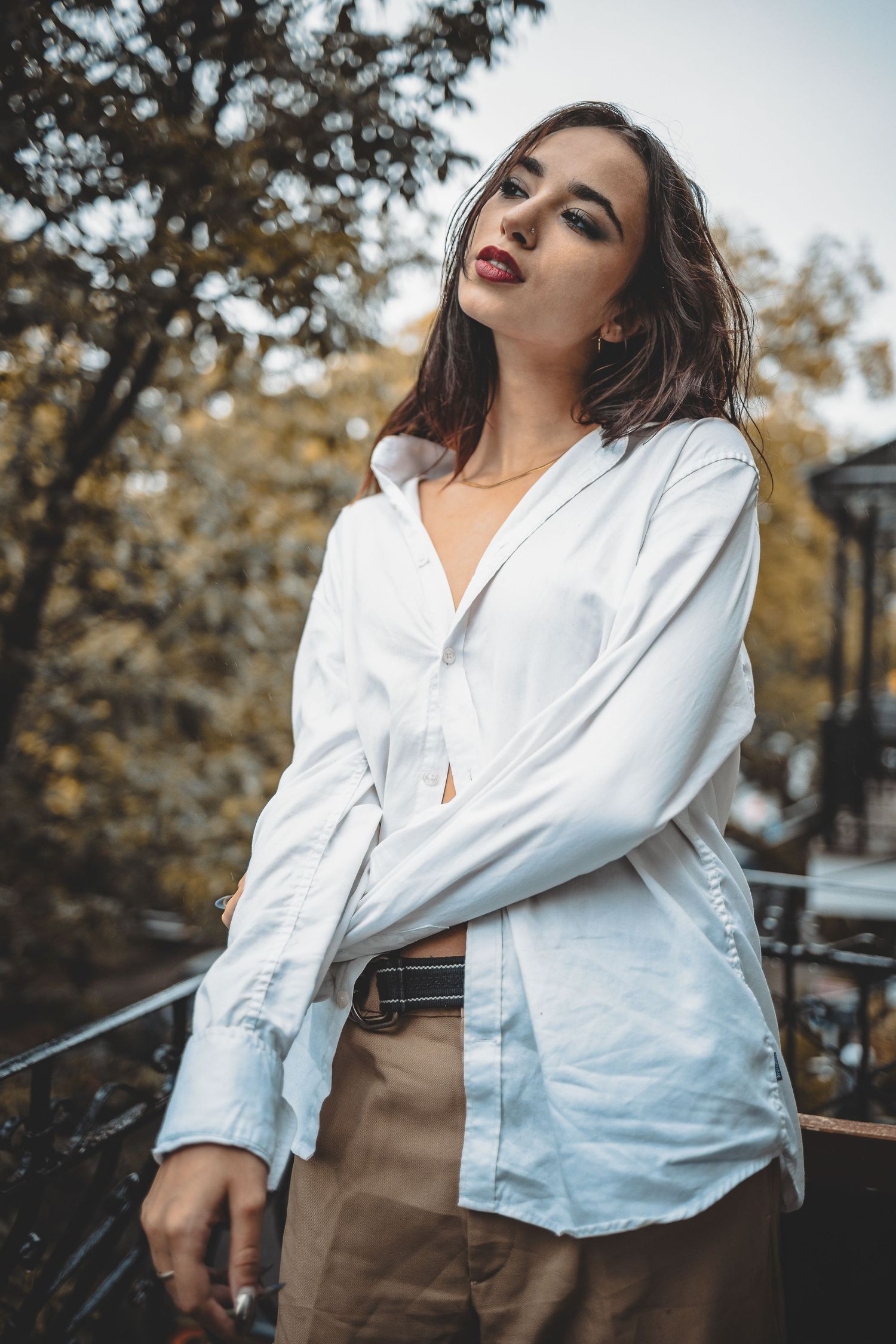 Fashion photography of white button-down shirt and tan pants in outdoor setting.