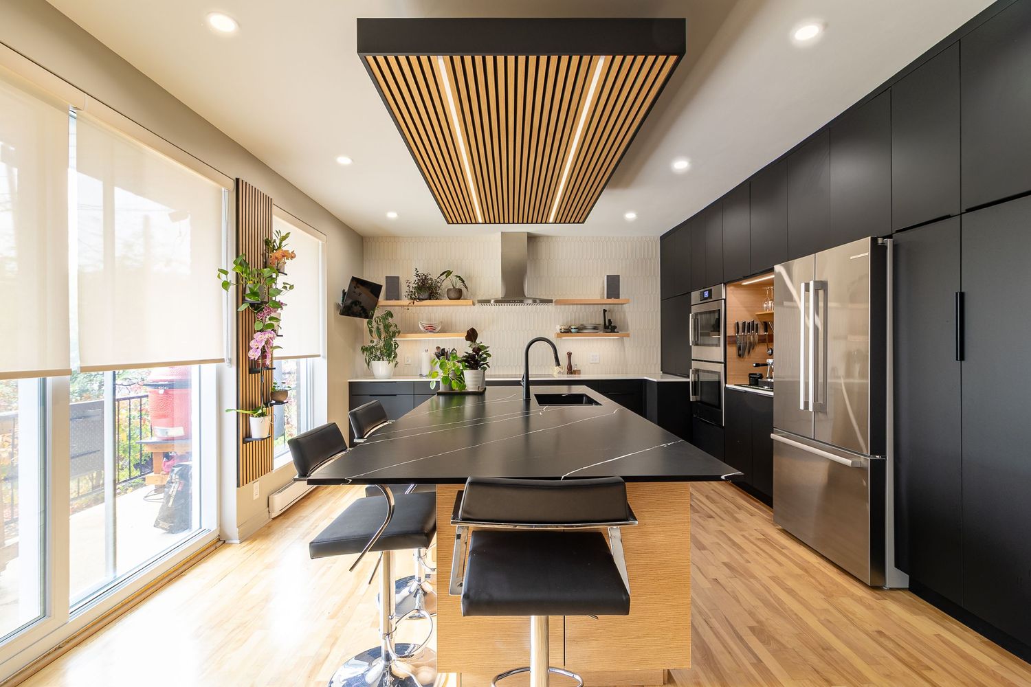 Contemporary kitchen design featuring black cabinetry and wooden slat ceiling details.