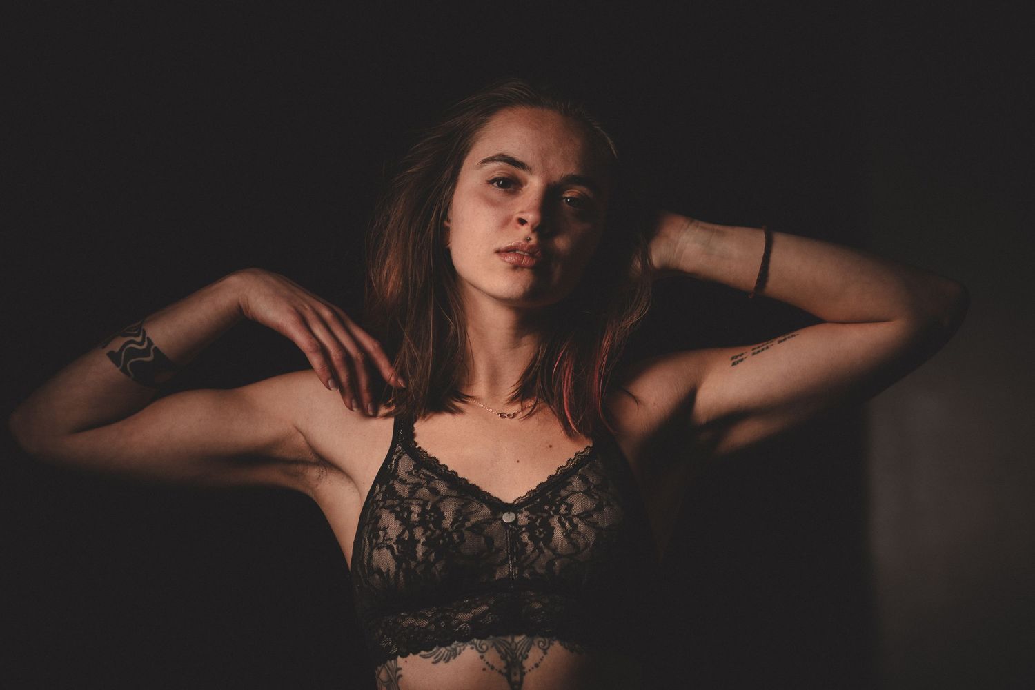 Artistic boudoir photography series in dark moody lighting with dramatic shadows.