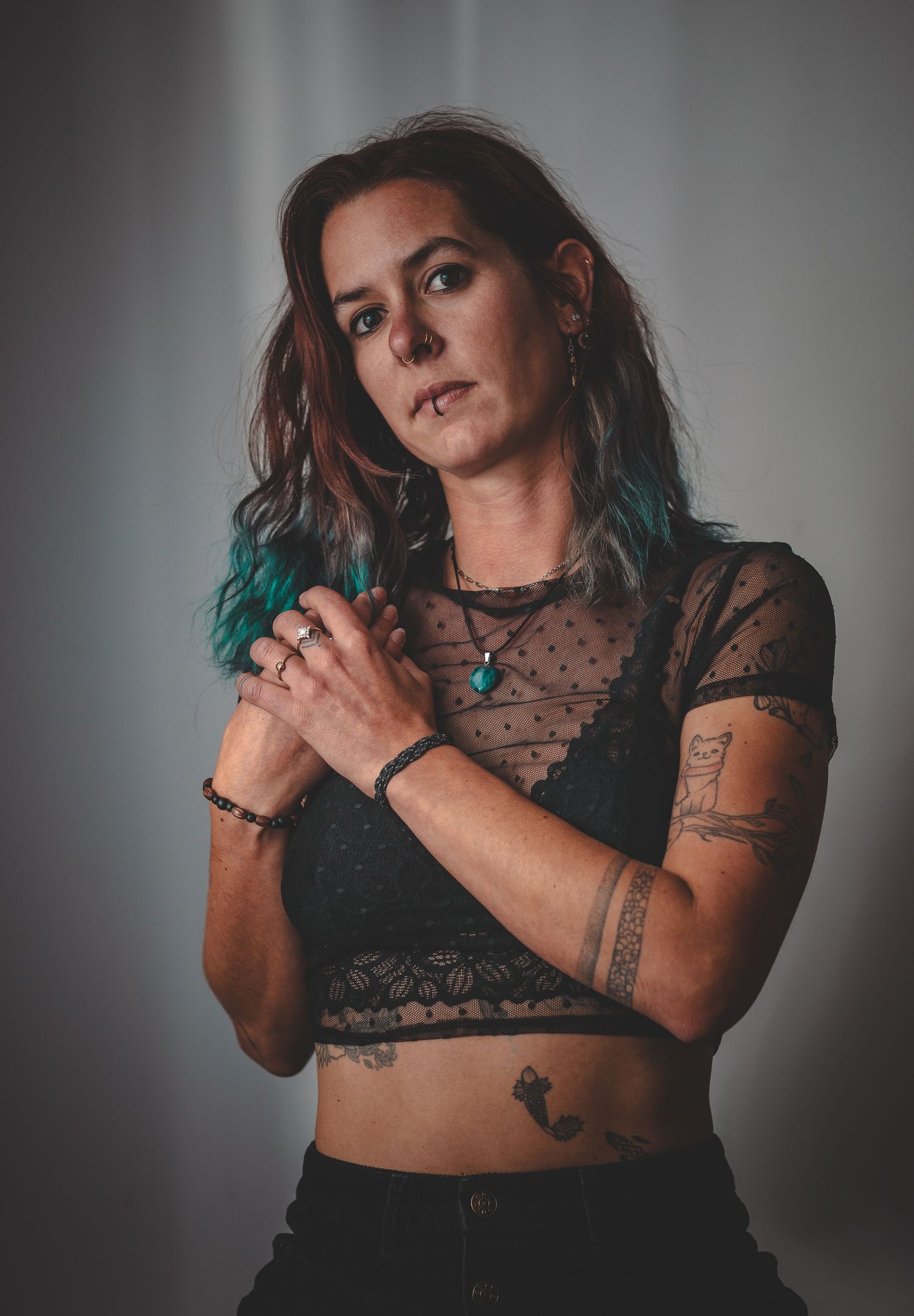 Moody boudoir photography featuring lace and tattoos against grey background.