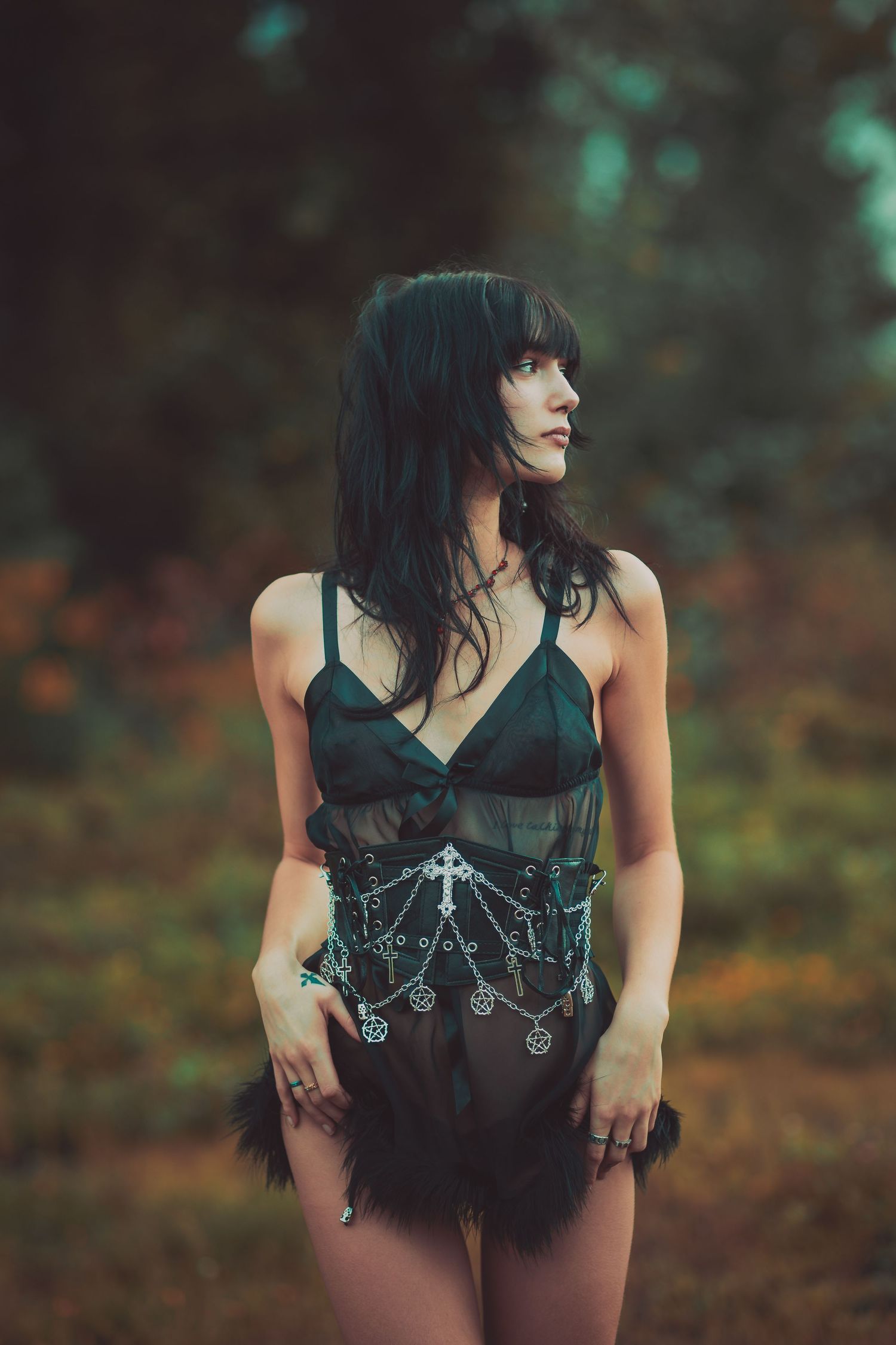 Fashion photography featuring dark romantic styling in autumn outdoor setting.