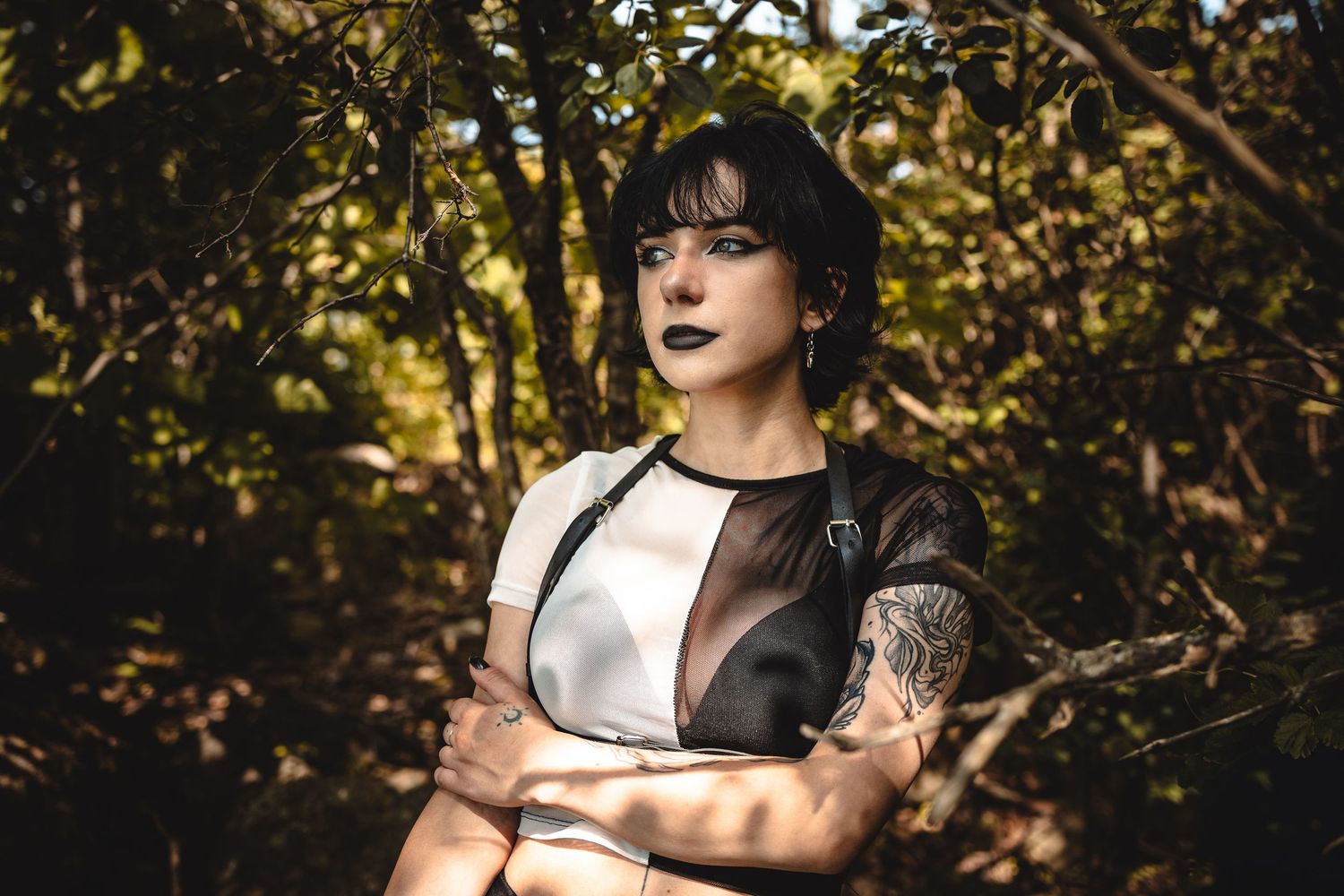 Dramatic outdoor portrait series with dappled sunlight filtering through autumn leaves.