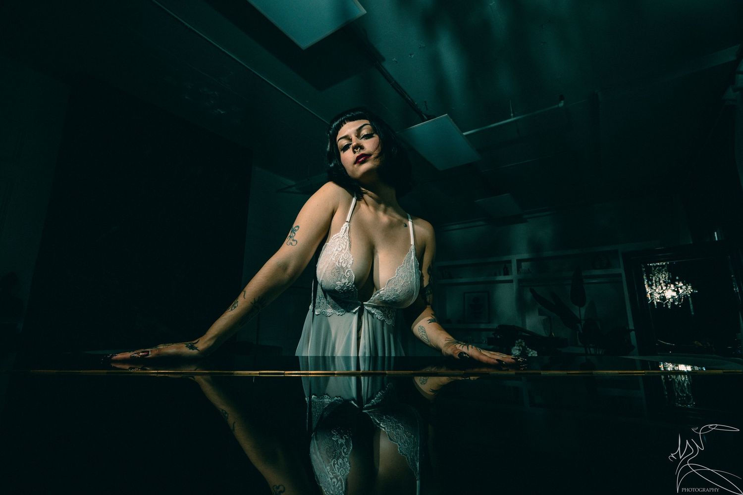 Artistic portrait session in dark moody lighting with reflective surfaces.