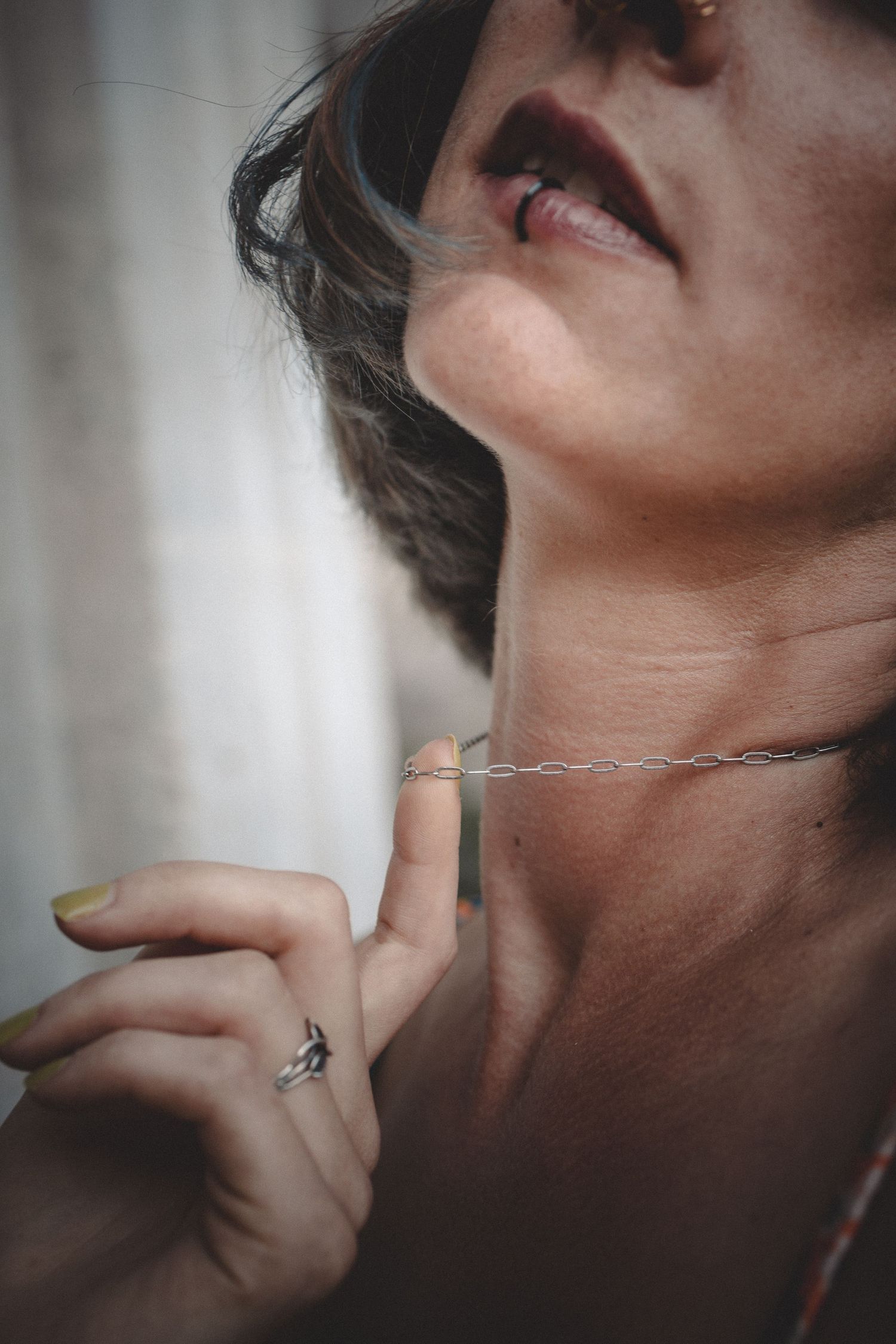 Close-up portrait series focusing on neck and jewelry details in dramatic lighting.
