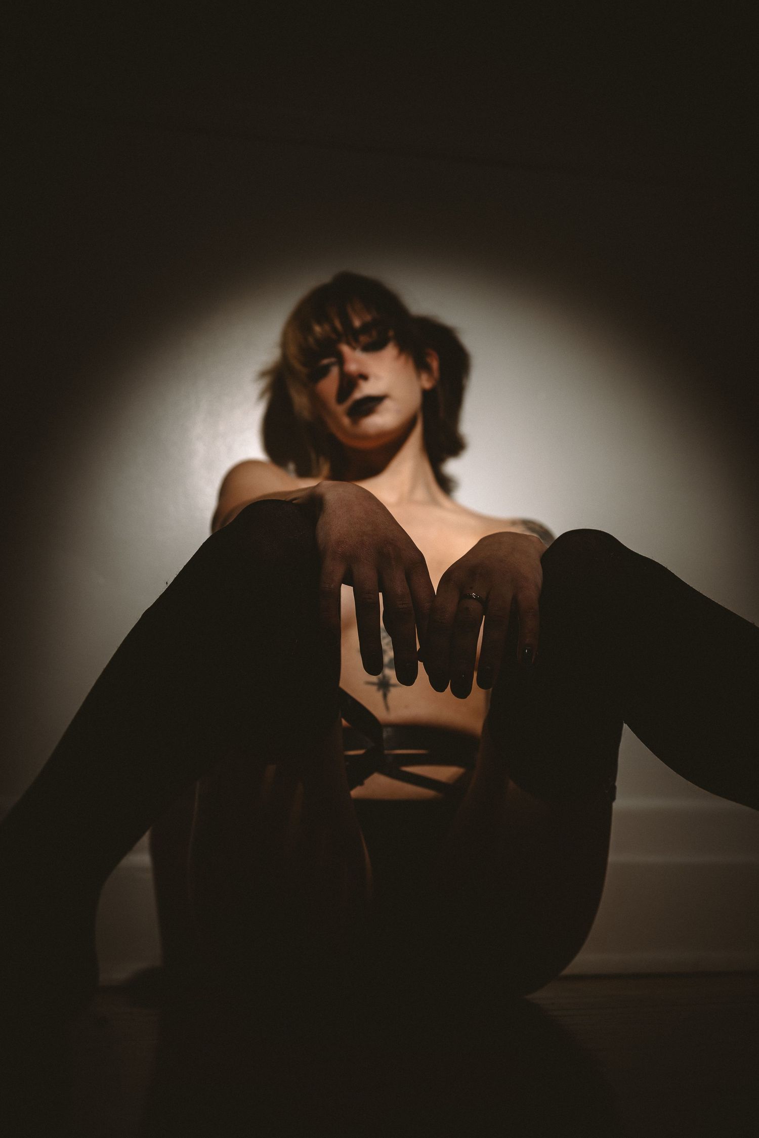 Dramatic chiaroscuro lighting creates moody atmosphere in artistic portrait.