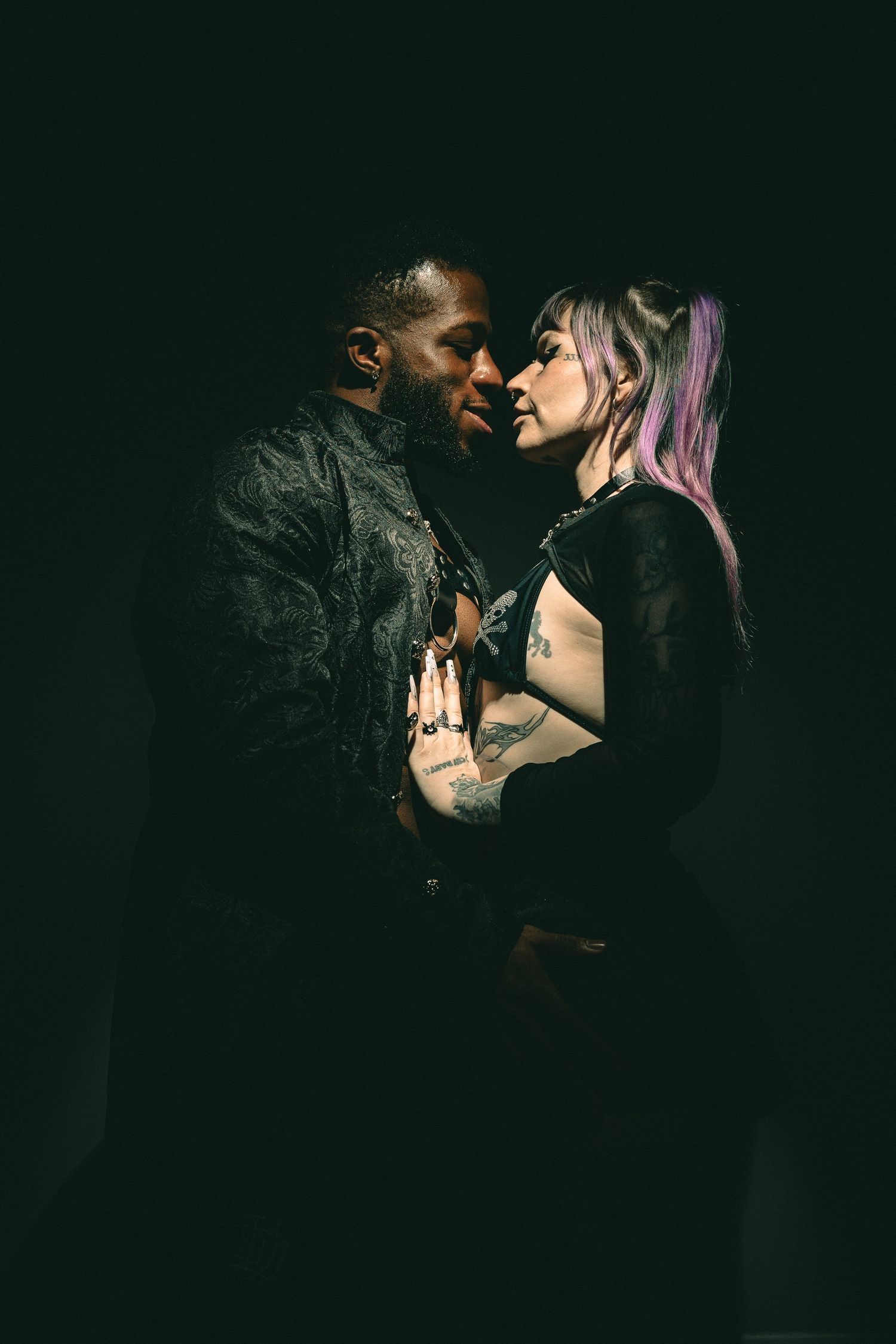 Intimate artistic portrait sequence showing couple in dark moody lighting.
