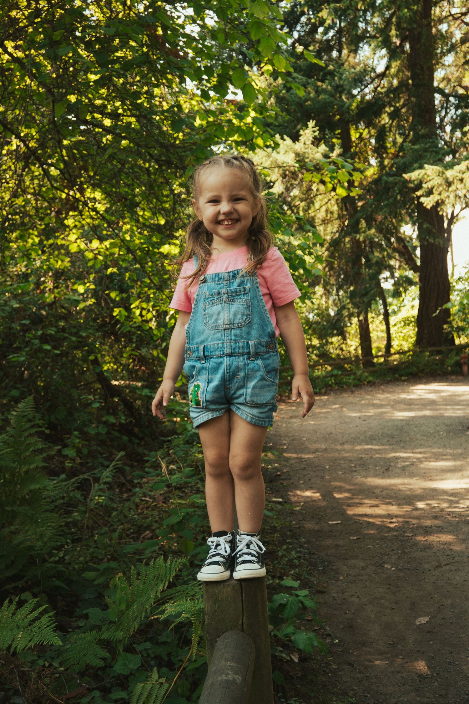 Joyful moment on a woodland path with sunlit trees in the background.