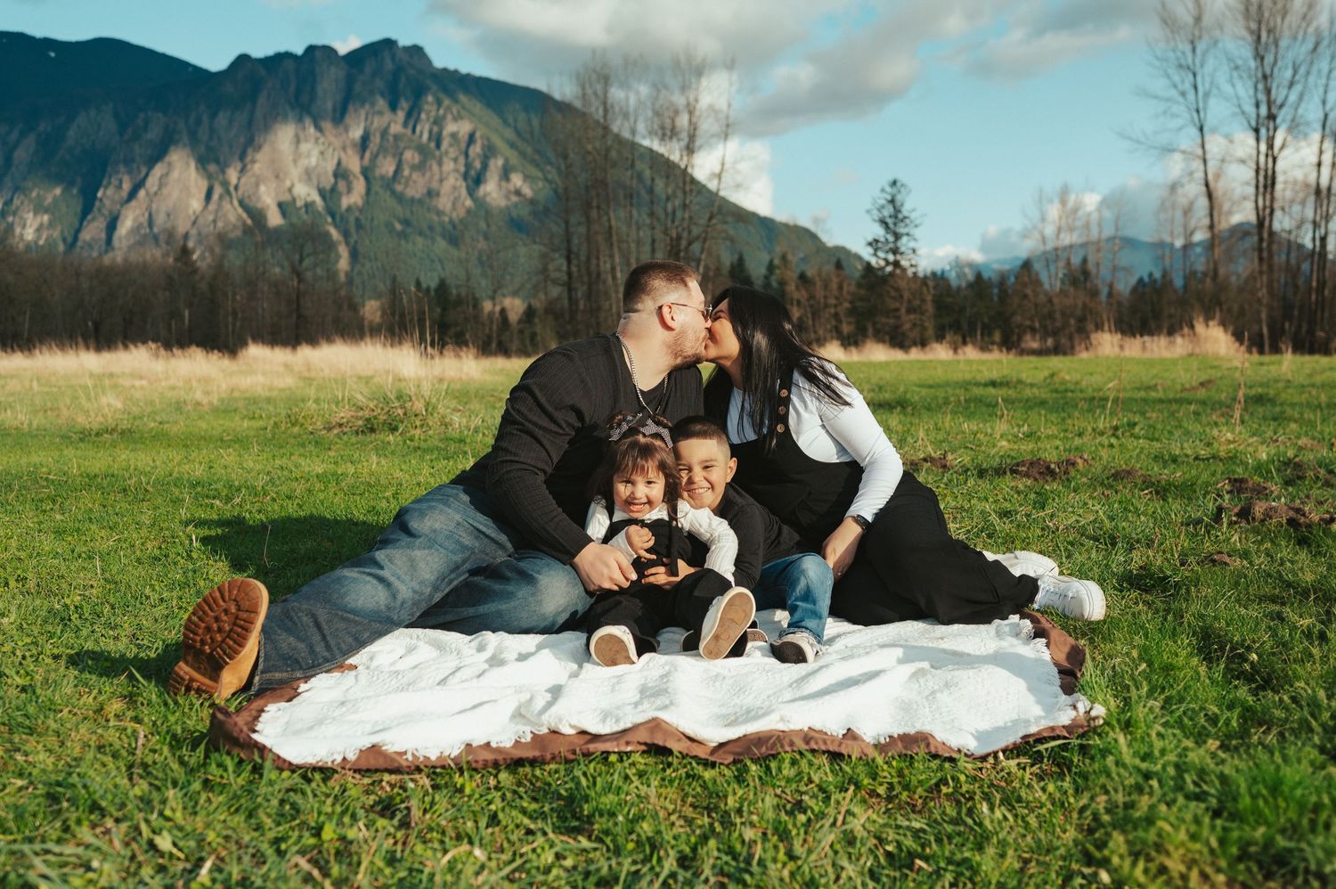 A collection of intimate family photographs against a dramatic mountain landscape backdrop.