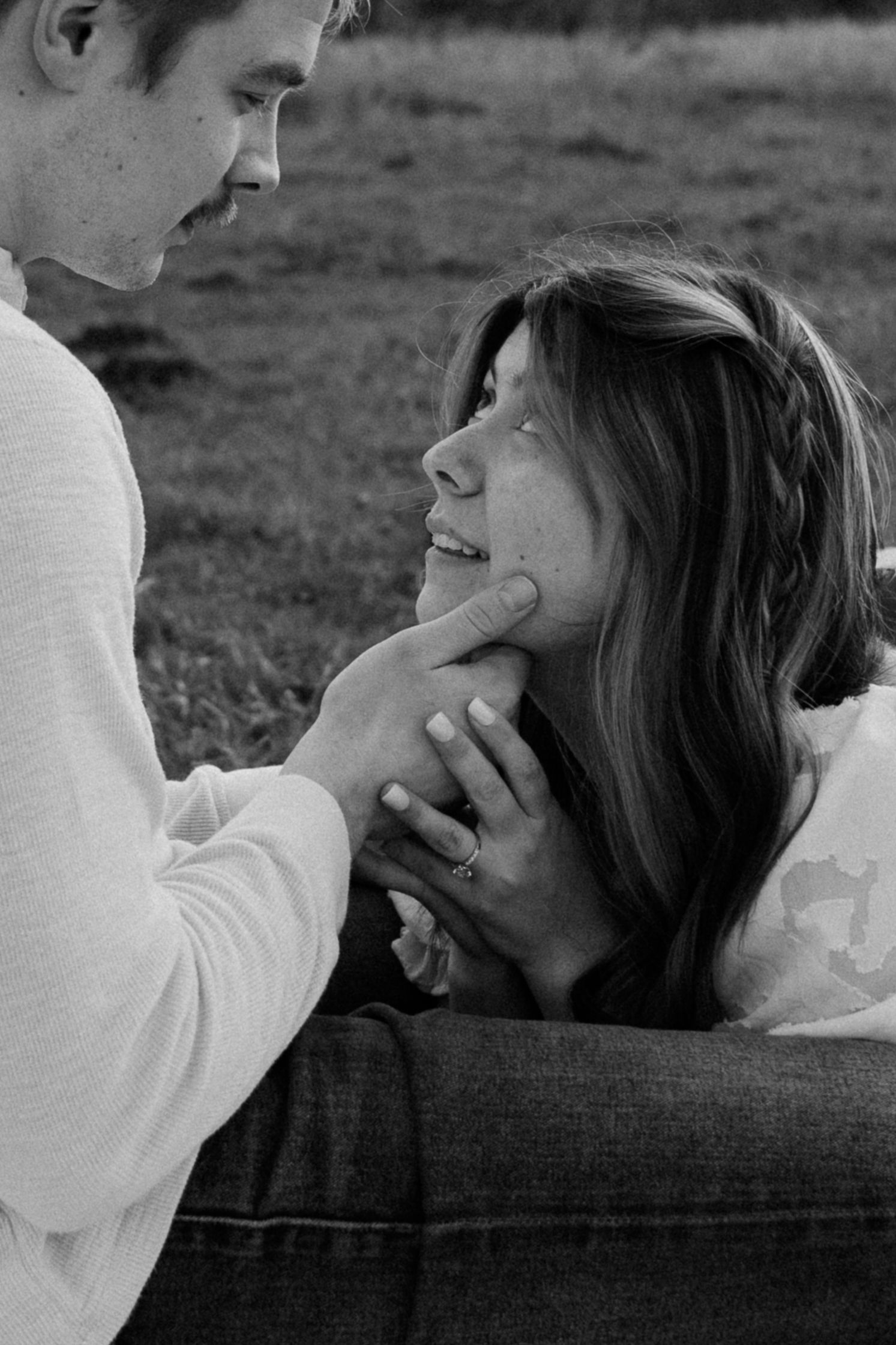Black and white portrait of couple sharing intimate moments during outdoor photoshoot.