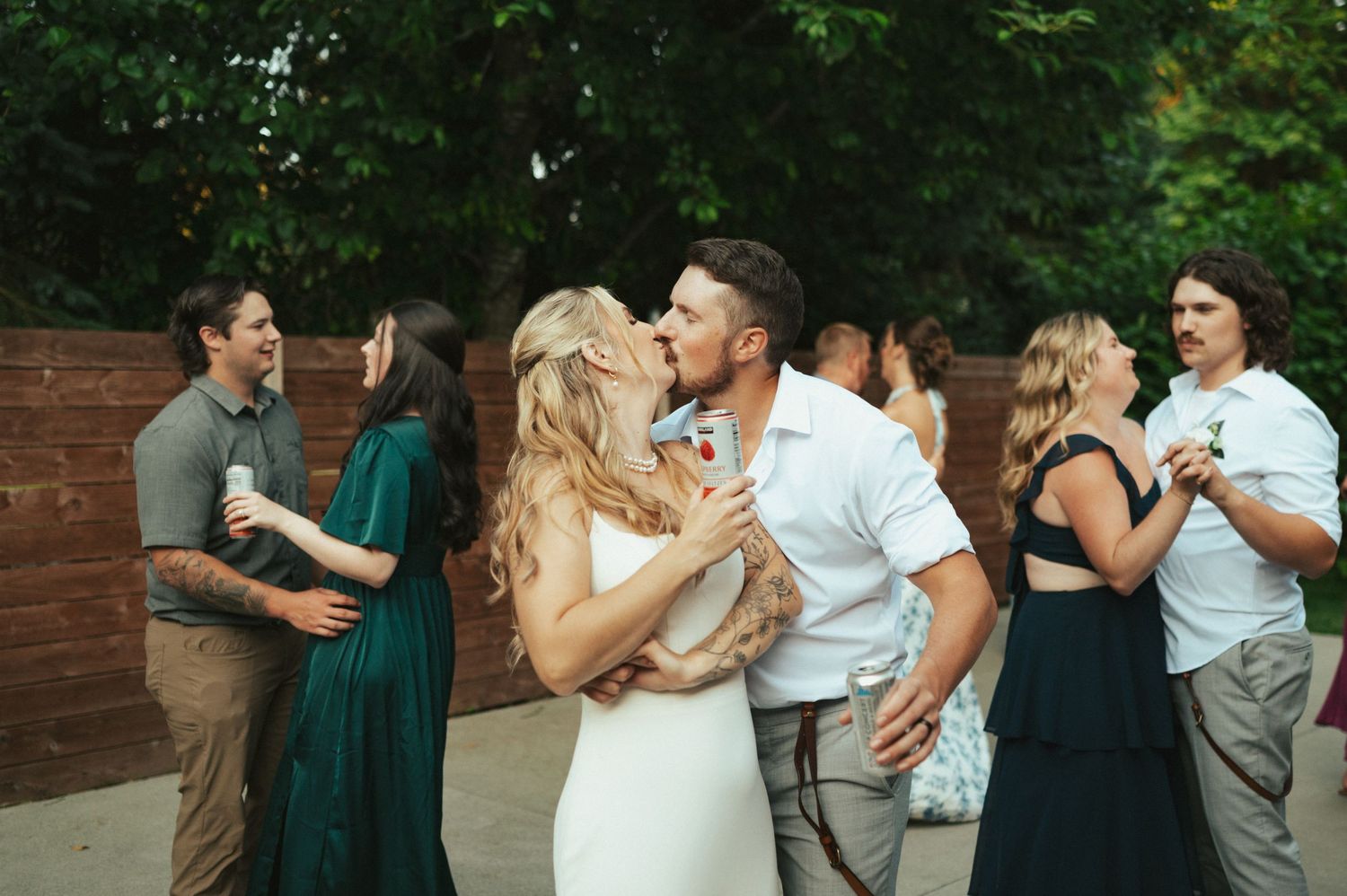 Wedding party dancing and celebrating at an outdoor reception.