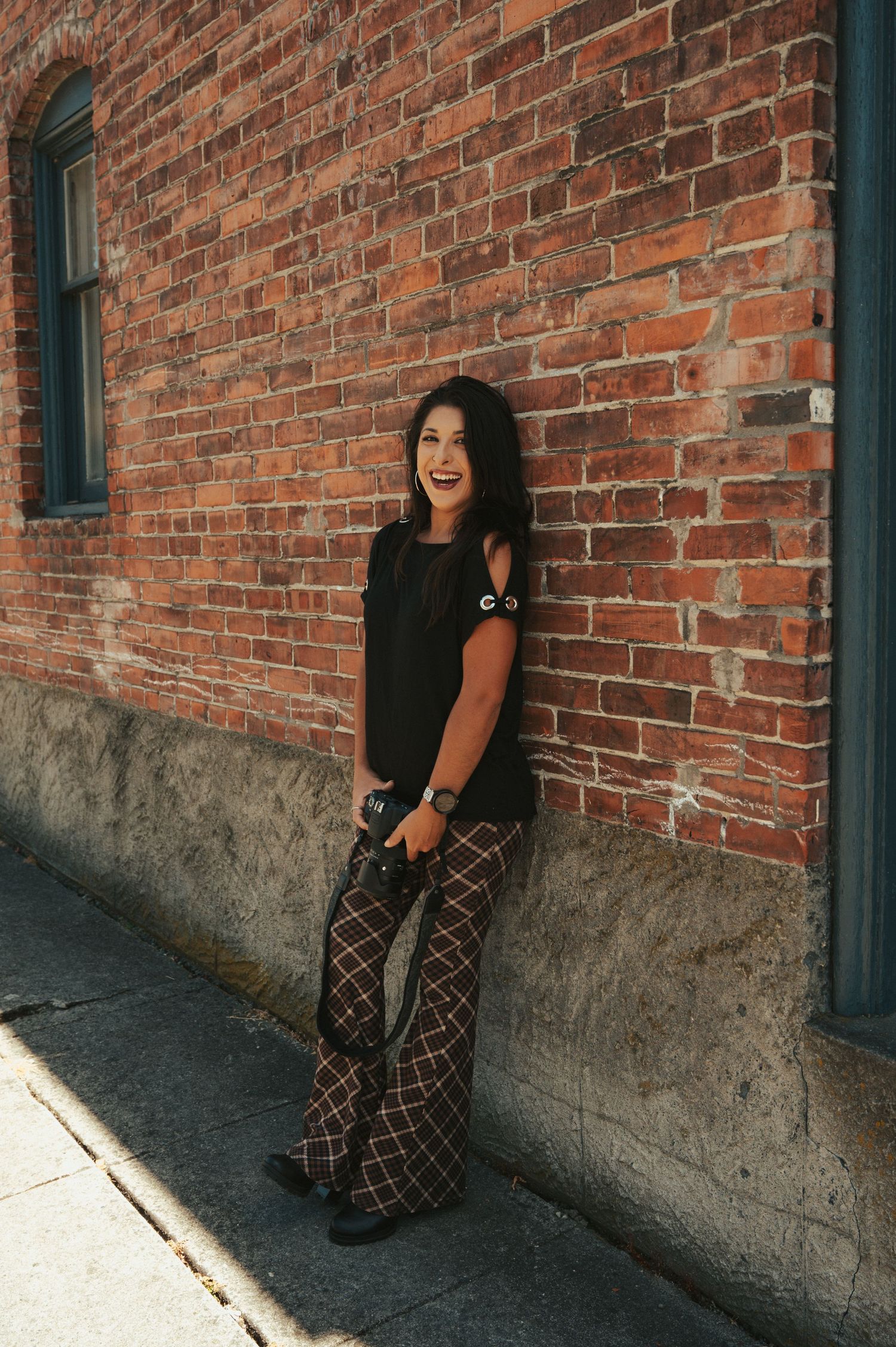 Four sequential photos show a person in black clothing sitting against a rustic brick wall in changing poses.