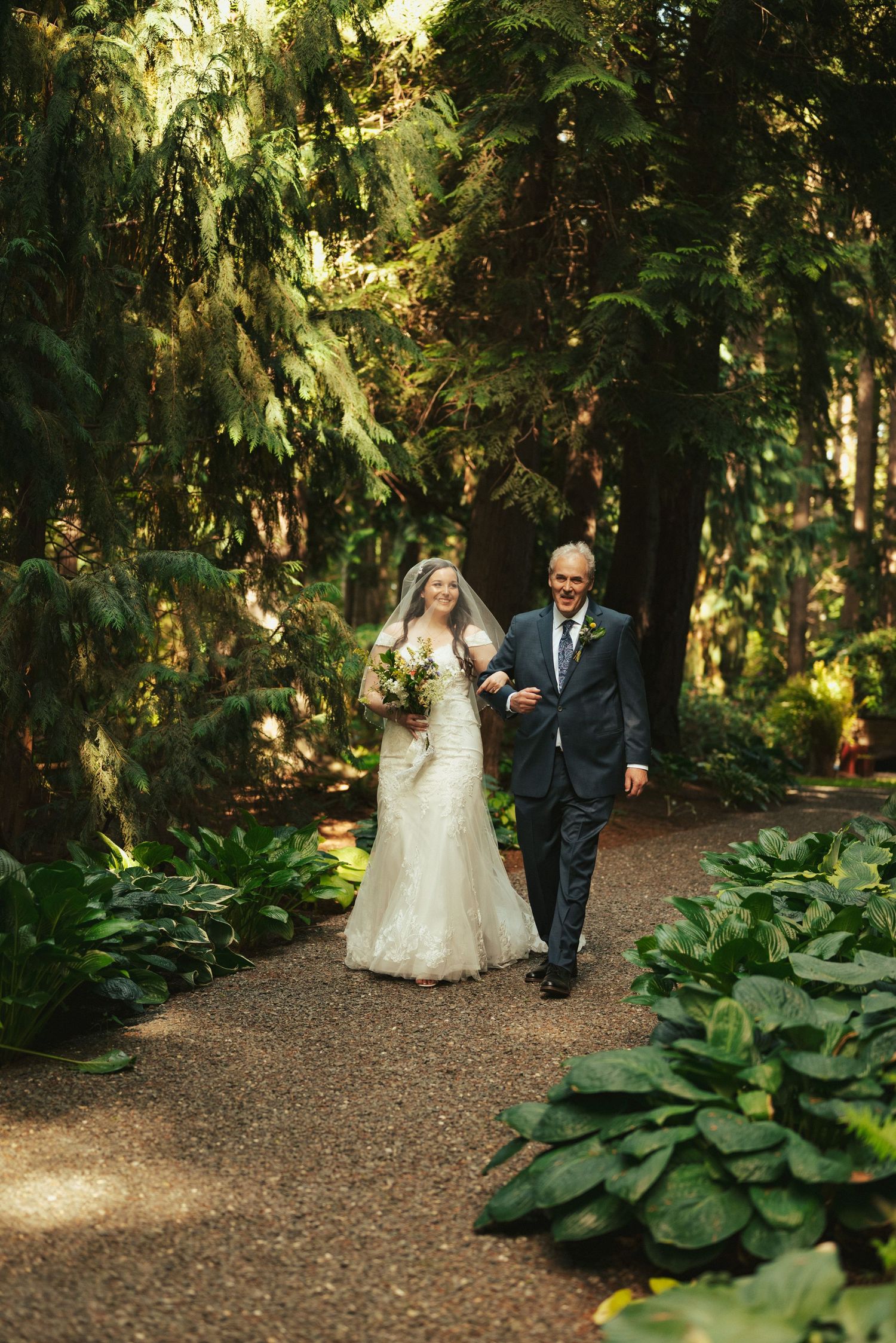 Walking together on a shaded forest path surrounded by lush green foliage.