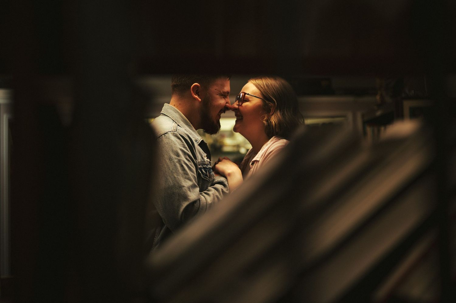Intimate dark and moody couple portrait with dramatic lighting and shadows.
