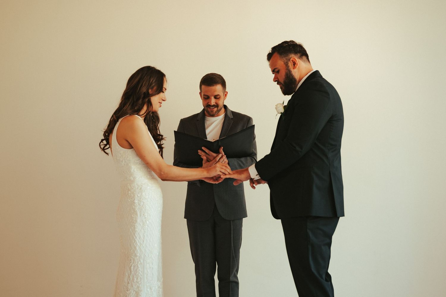 Wedding ceremony participants sharing intimate moments in front of forest backdrop at outdoor venue.