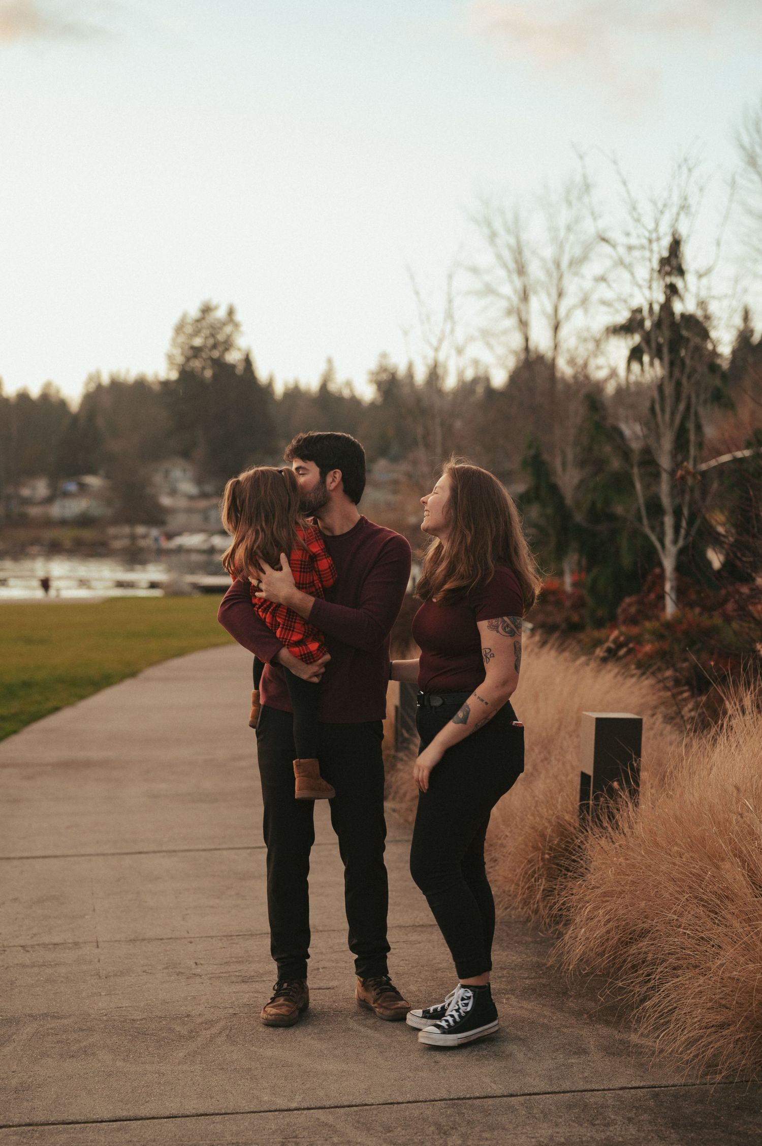 Family interaction captured at sunset on a paved pathway with ornamental grasses.