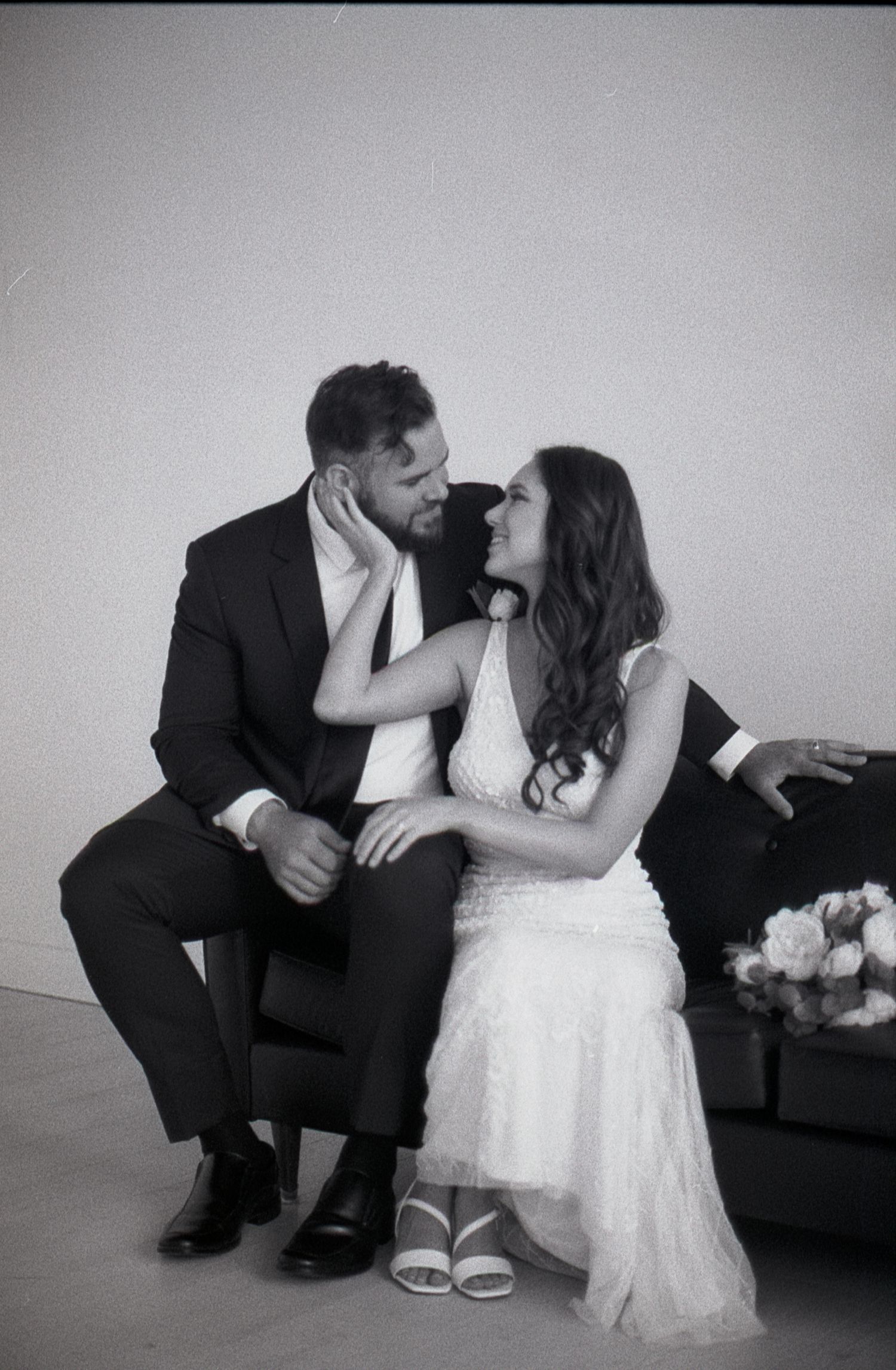 A tender moment between a couple sitting together in wedding attire.