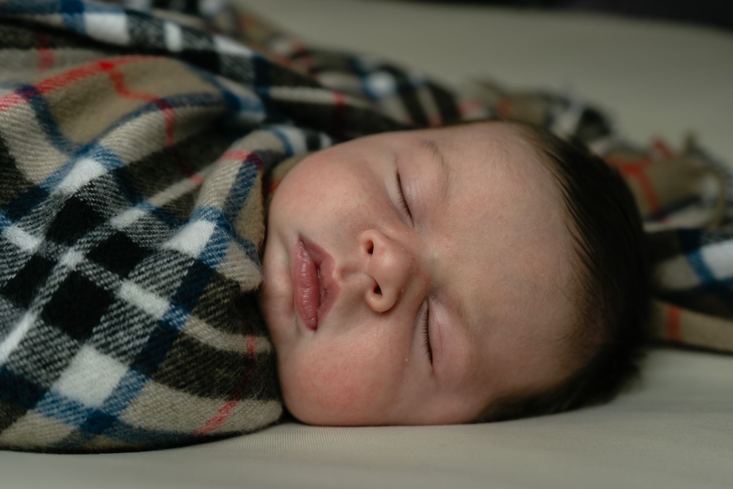 young baby photographed wrapped in family tartan.