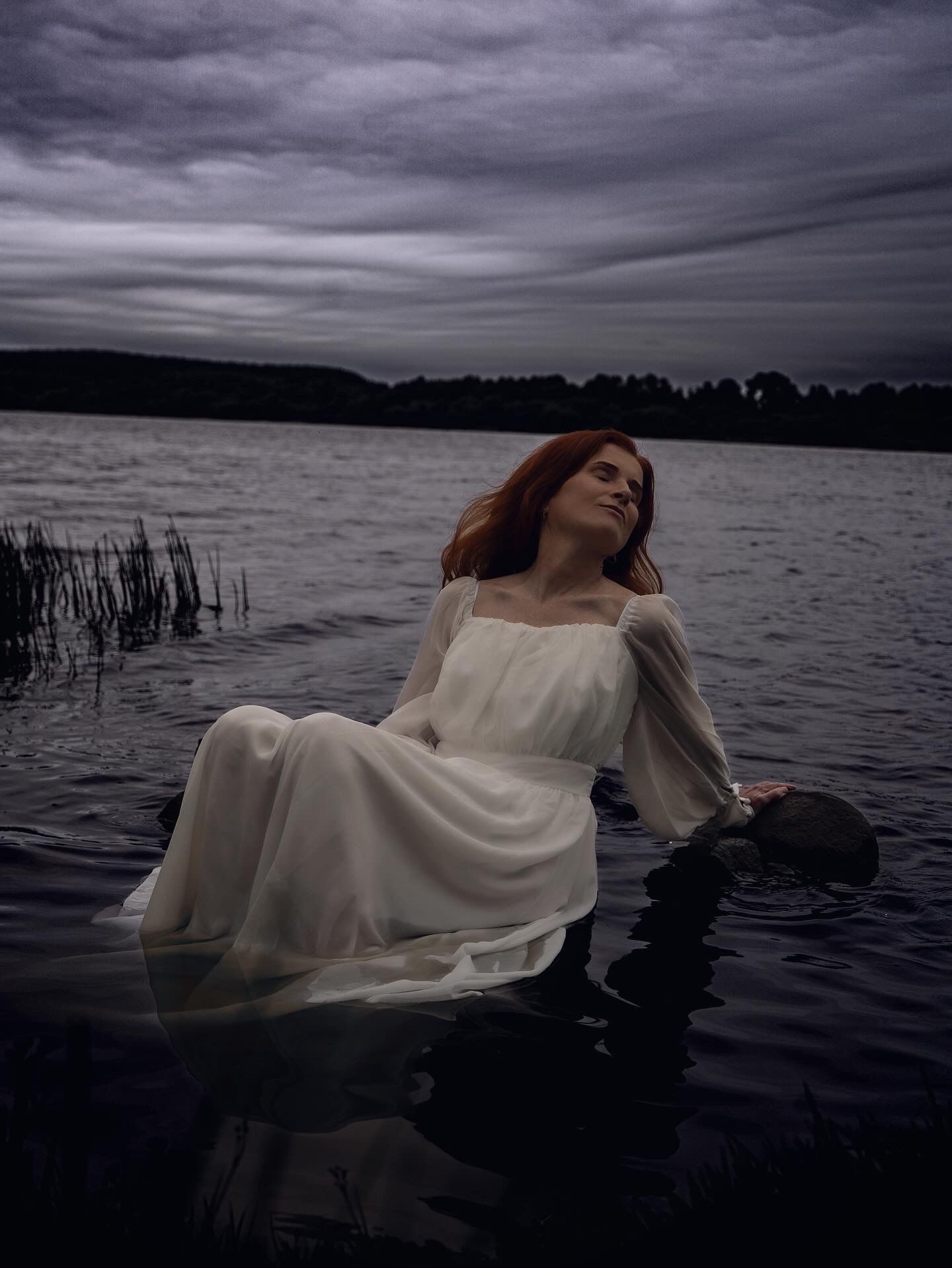 Photo of woman in long white dress on the water line in North Lanarkshire.