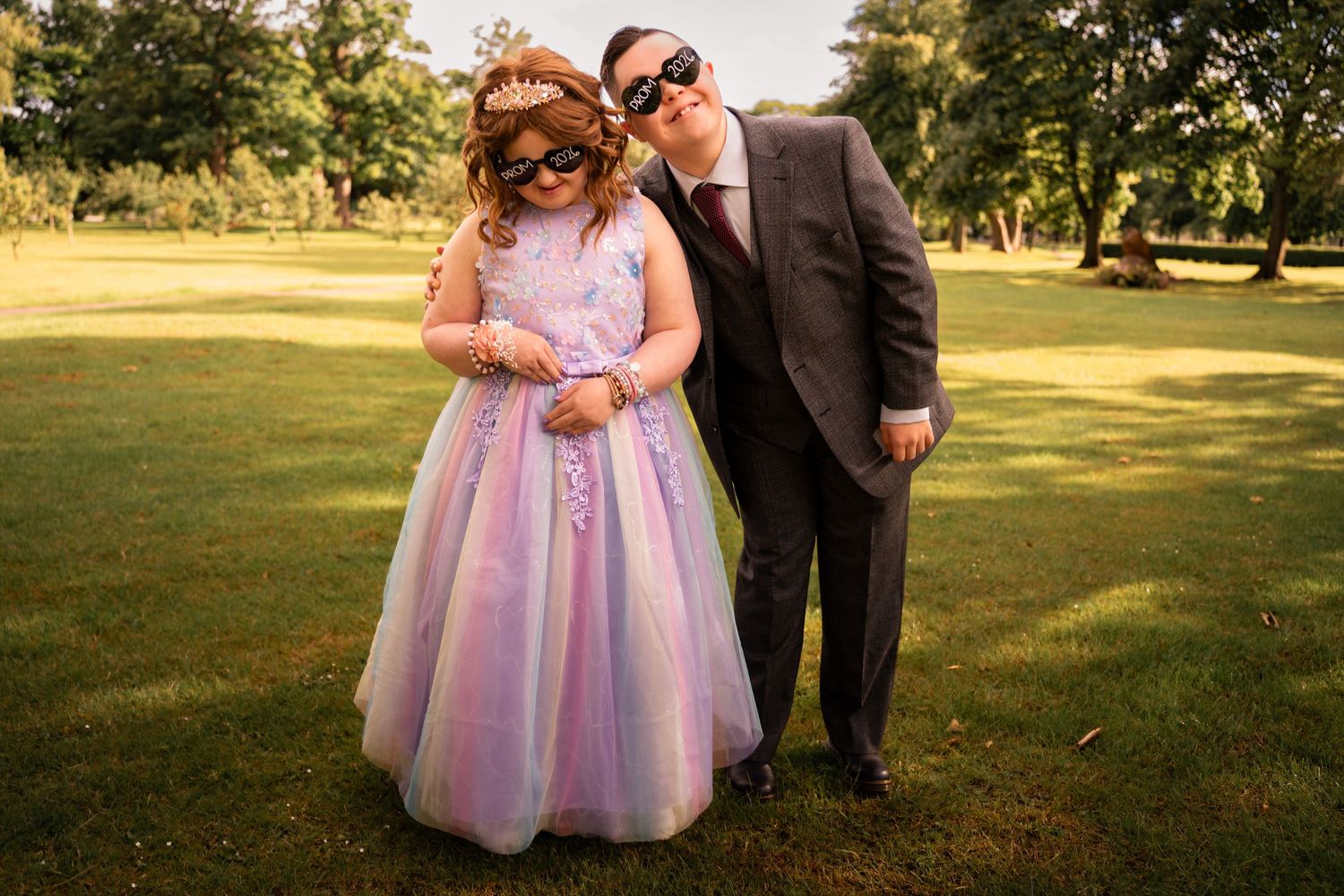 Prom photography Grangemouth 2026 of two friends at Zetland Park, one in pink and purple dress and one in grey suit