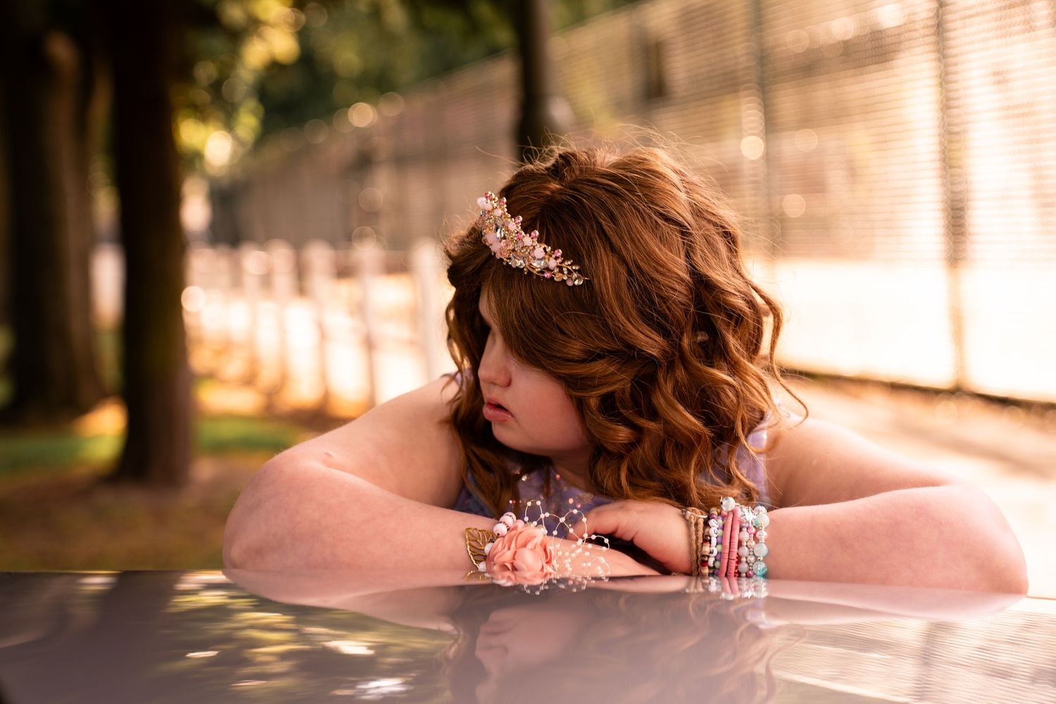 Prom photography showing a young girl leaning on a car in prom dress in Falkirk