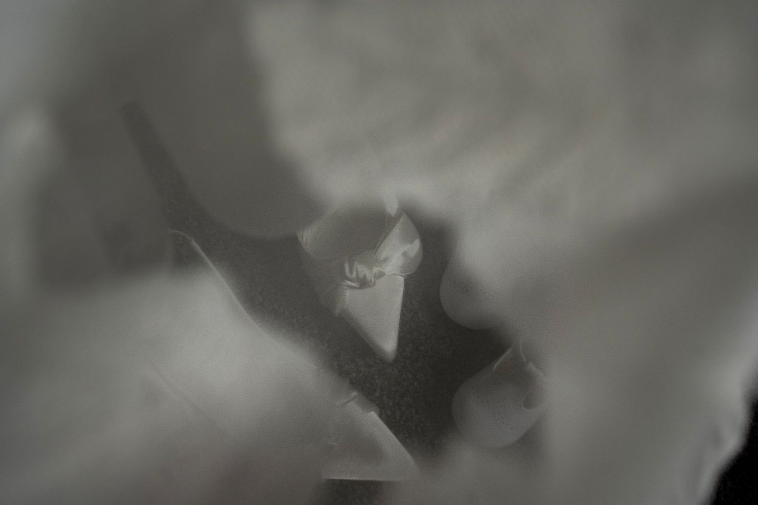 Mum and babies shoes, seen through the lace of a white dress.