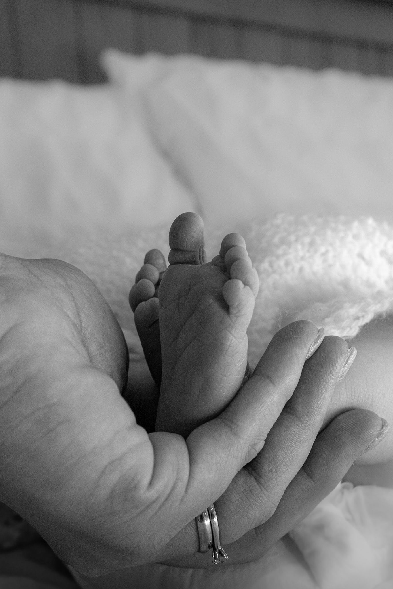 tiny baby foot photographed resting on mums hand.