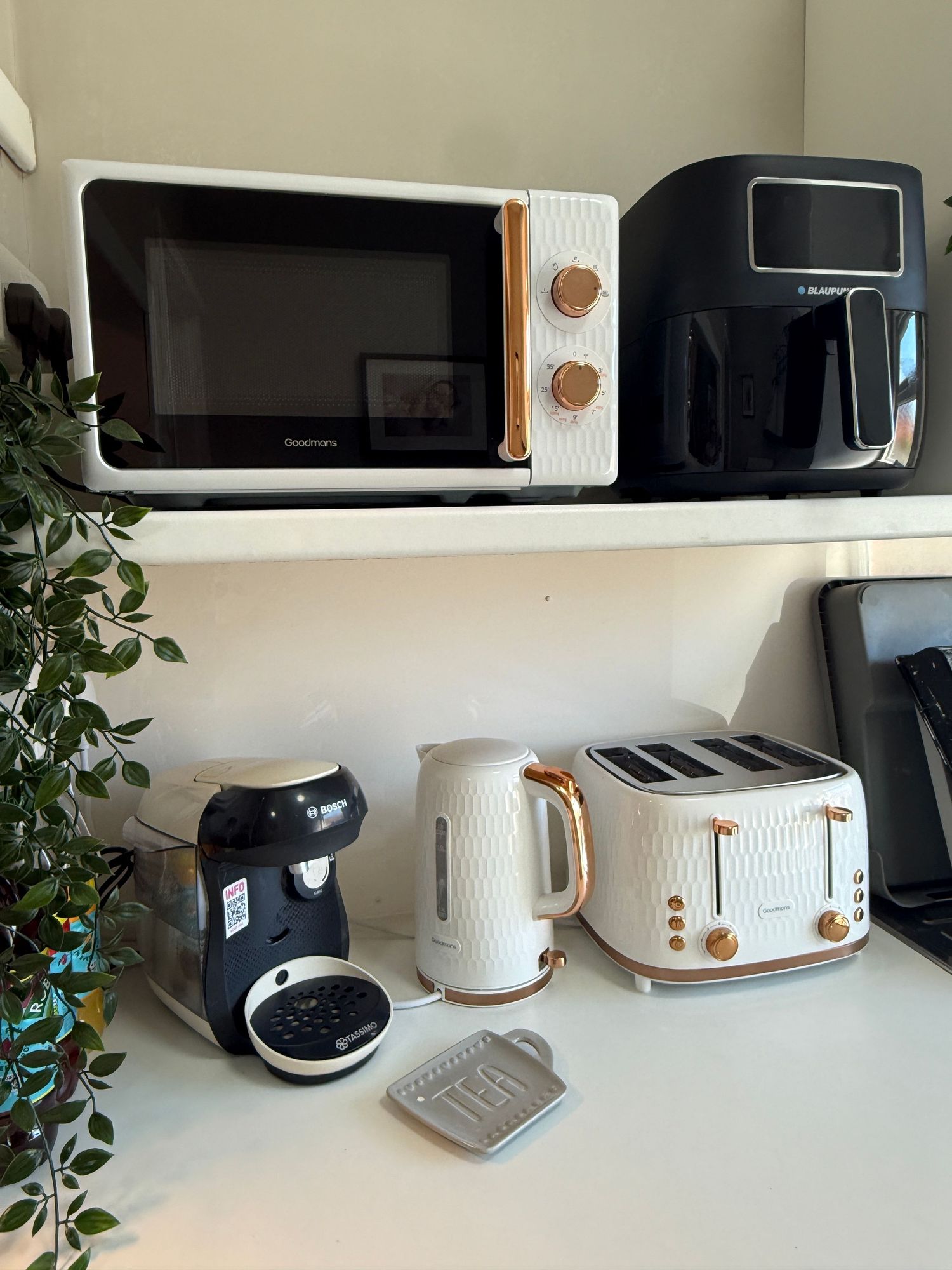 White and rose gold kitchen appliances set including microwave, air fryer, coffee machine, kettle, and 4-slice toaster on counter.