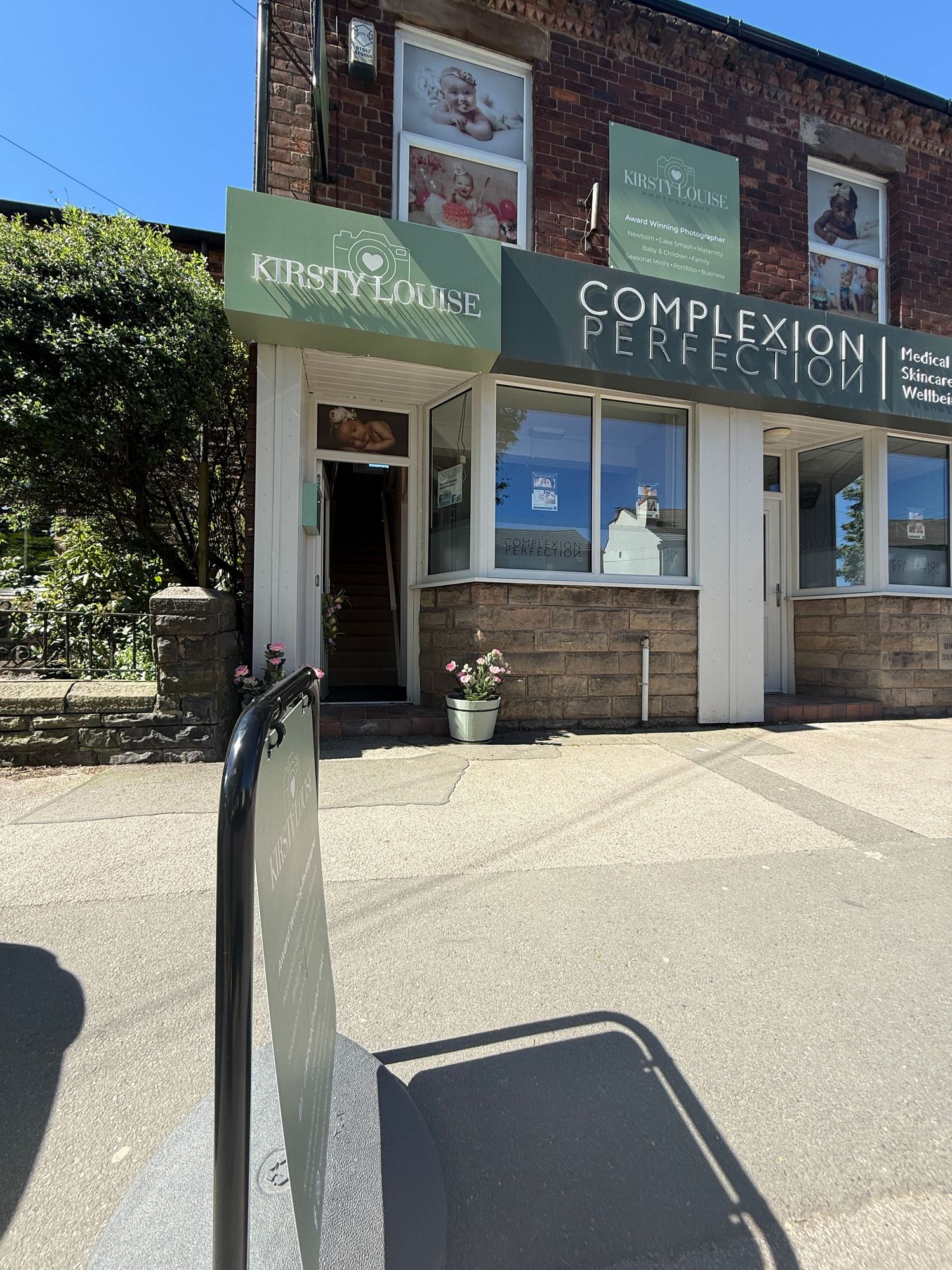 Kirsty Louise and Complexion Perfection beauty salon storefront on a sunny day in a brick building.